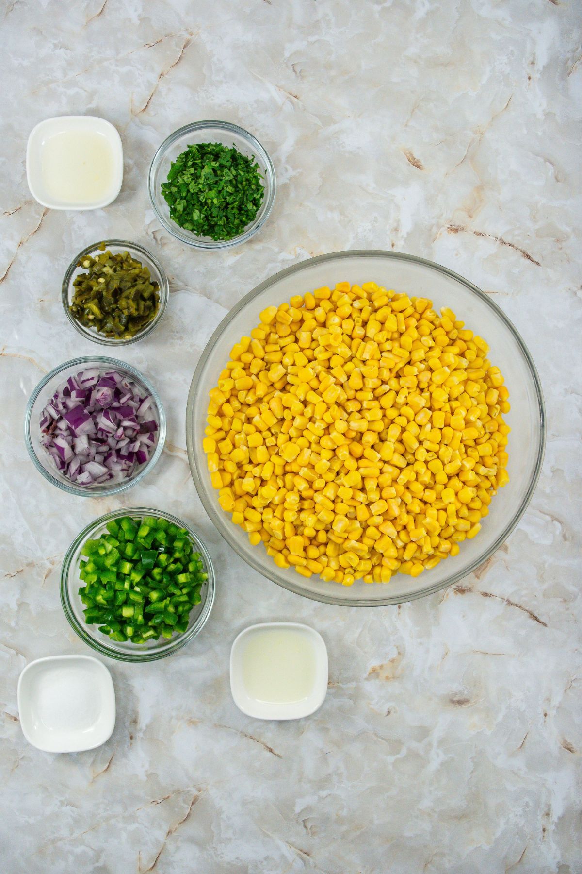 Chipotle corn salsa ingredients on a marble counter.