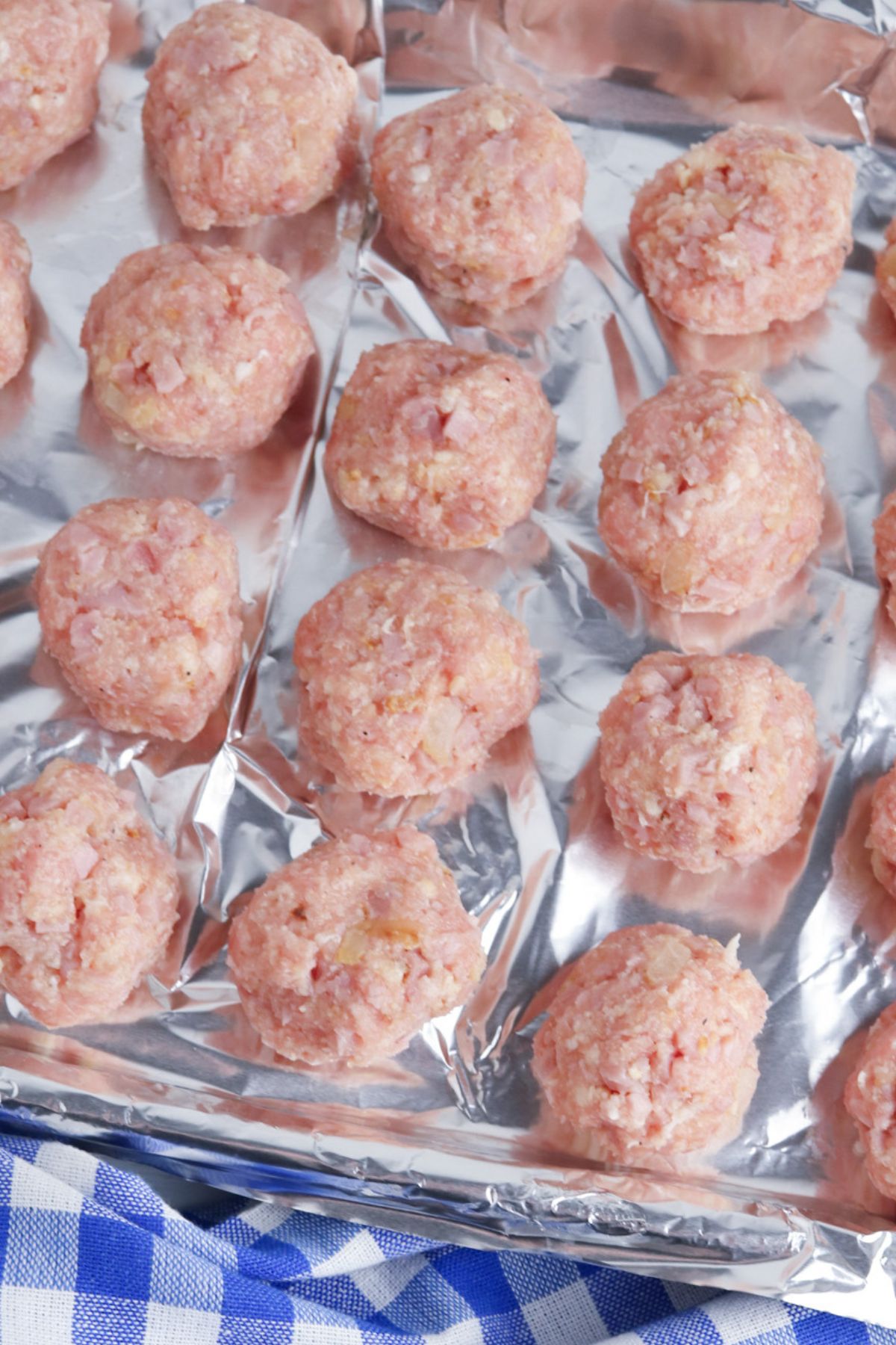 Rolled meatballs on a baking sheet.