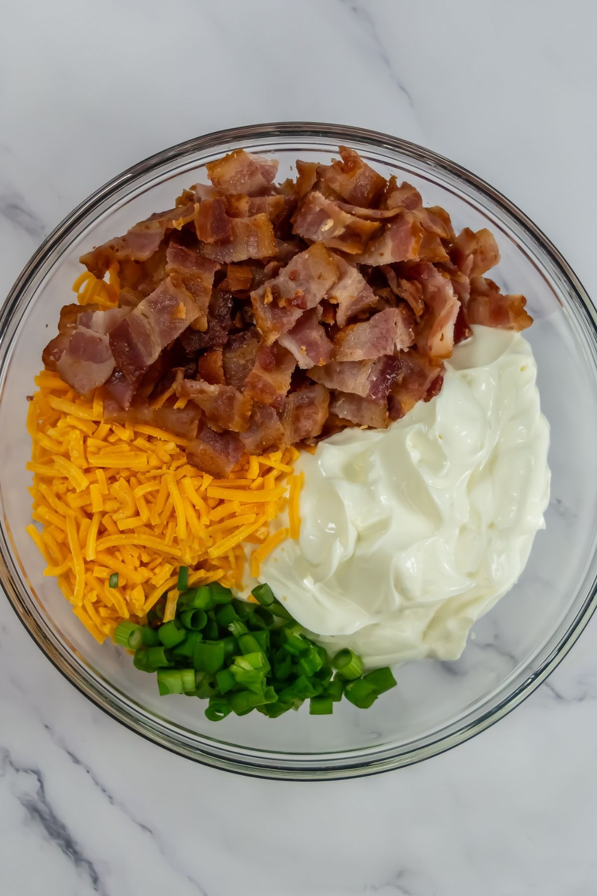 Baked potato dip ingredients in bowl.