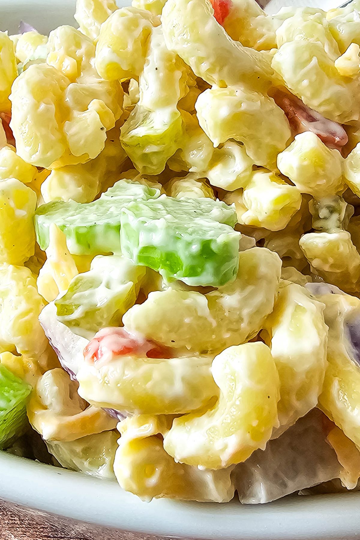 Macaroni salad in a white bowl.