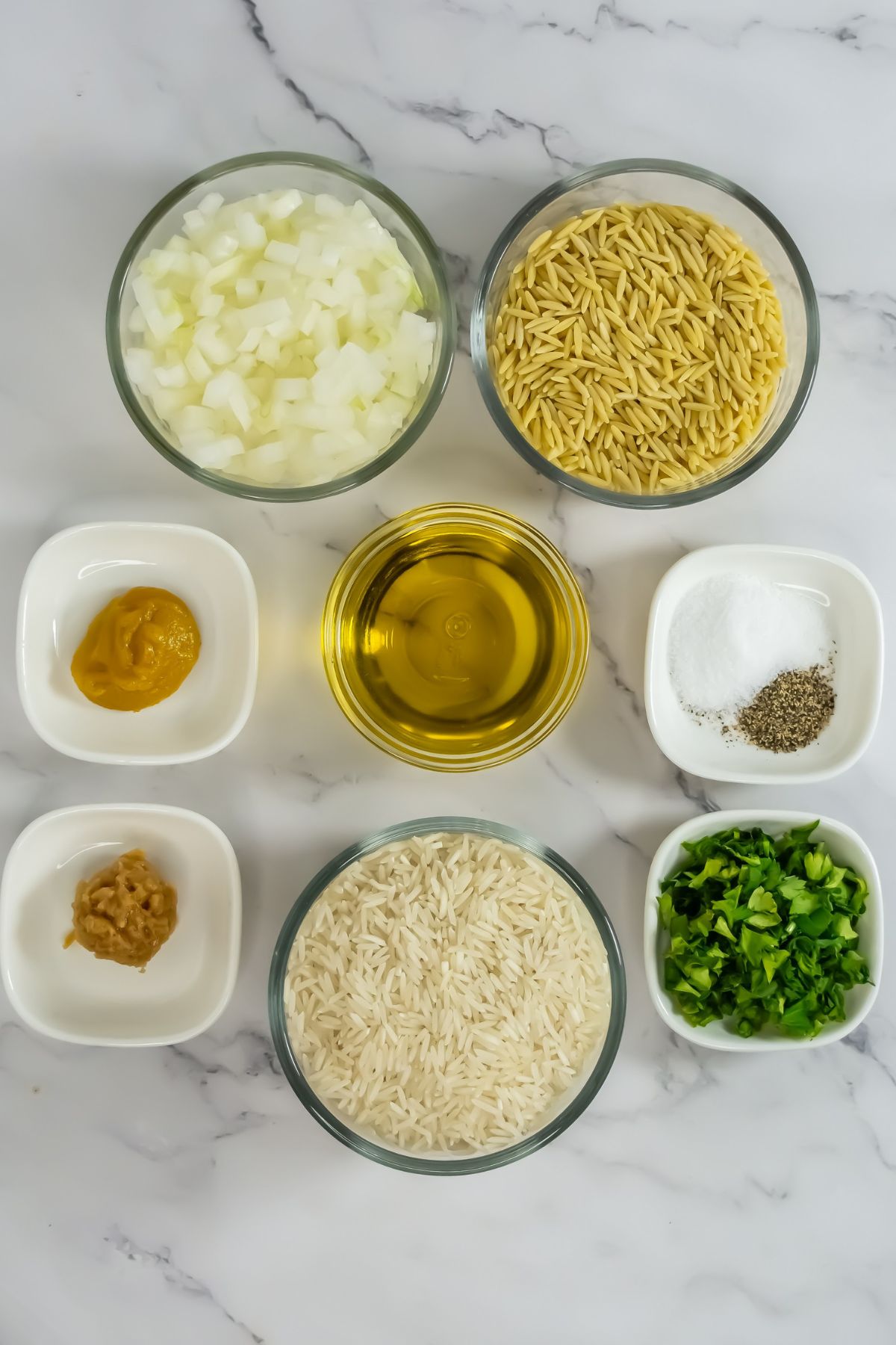 Orzo rice pilaf ingredients on a marble counter.
