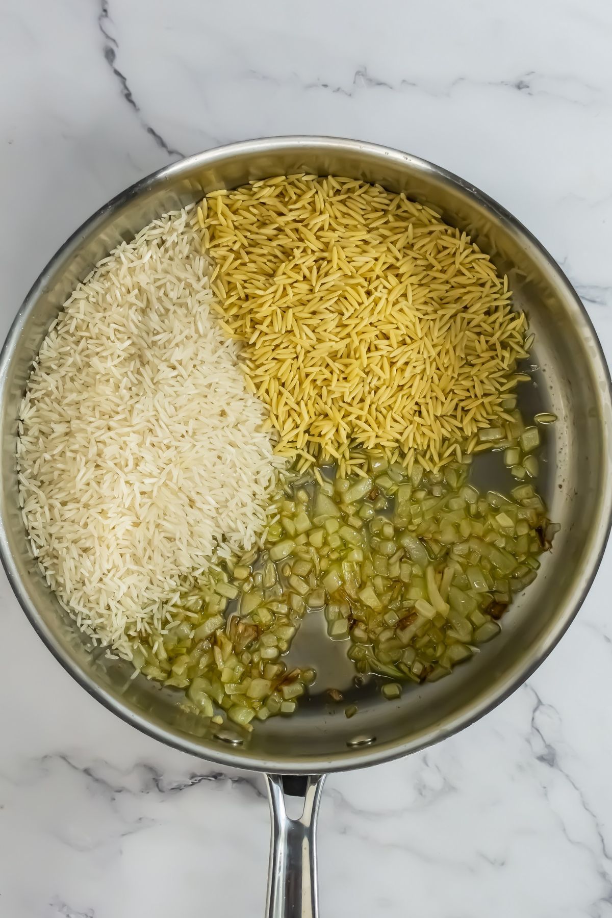 Rice and orzo in skillet.