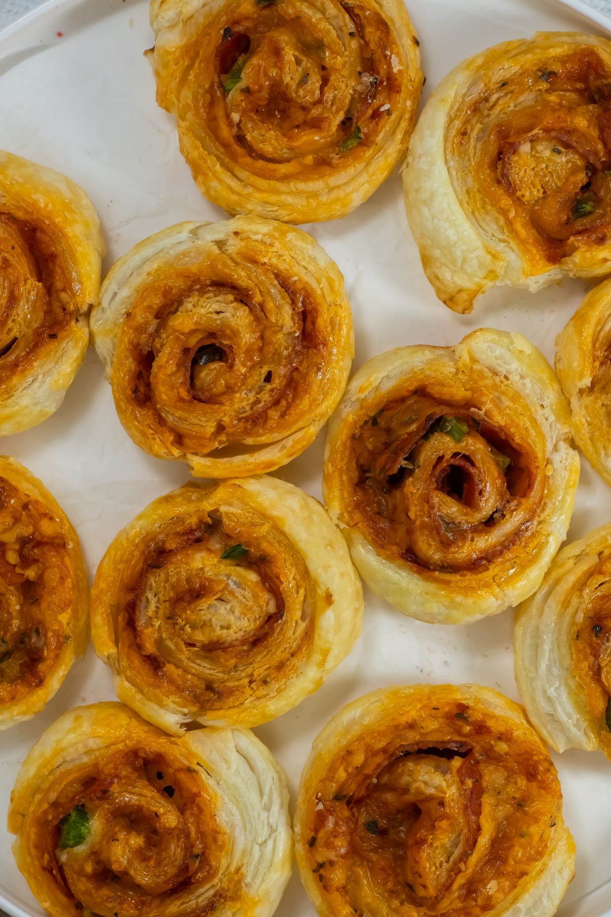 Pizza pinwheels on a white surface.