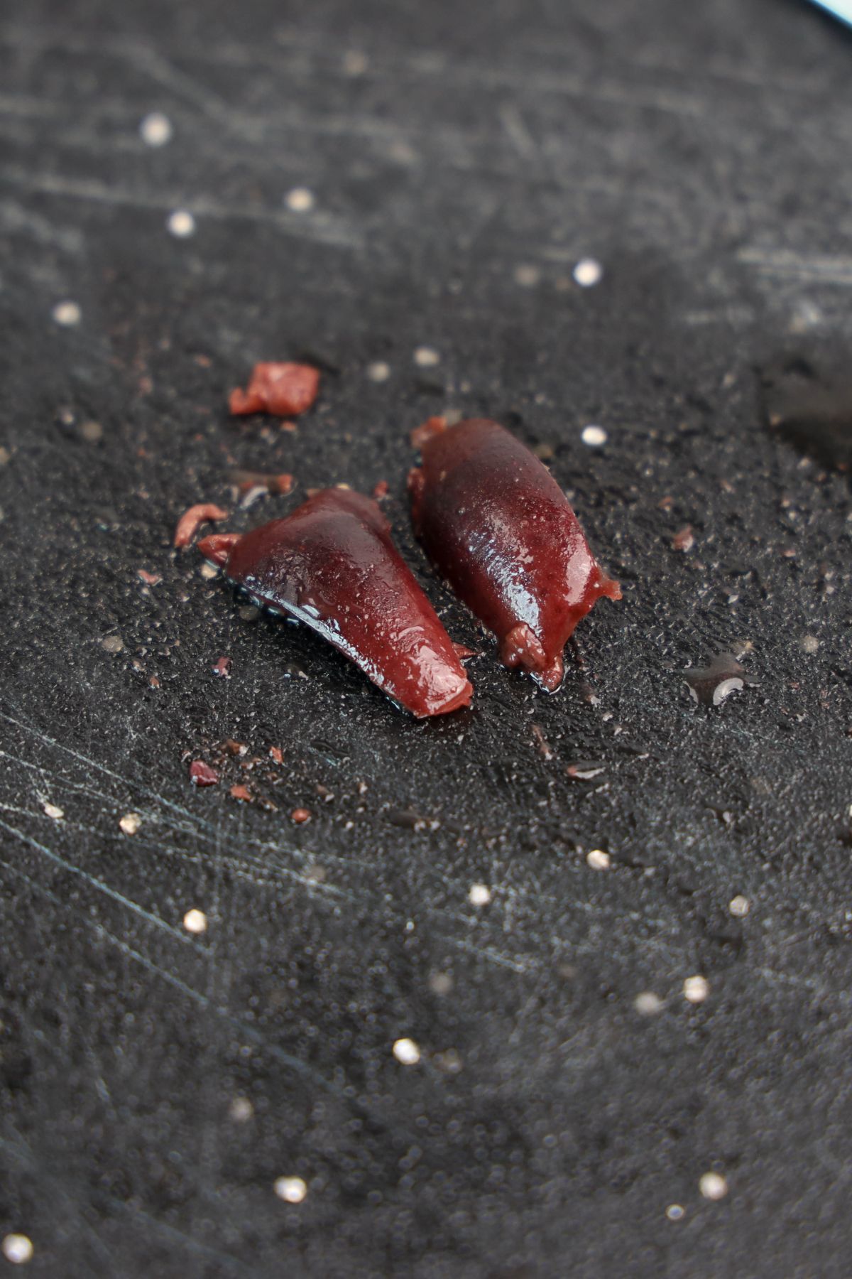Olives cut on a black counter.