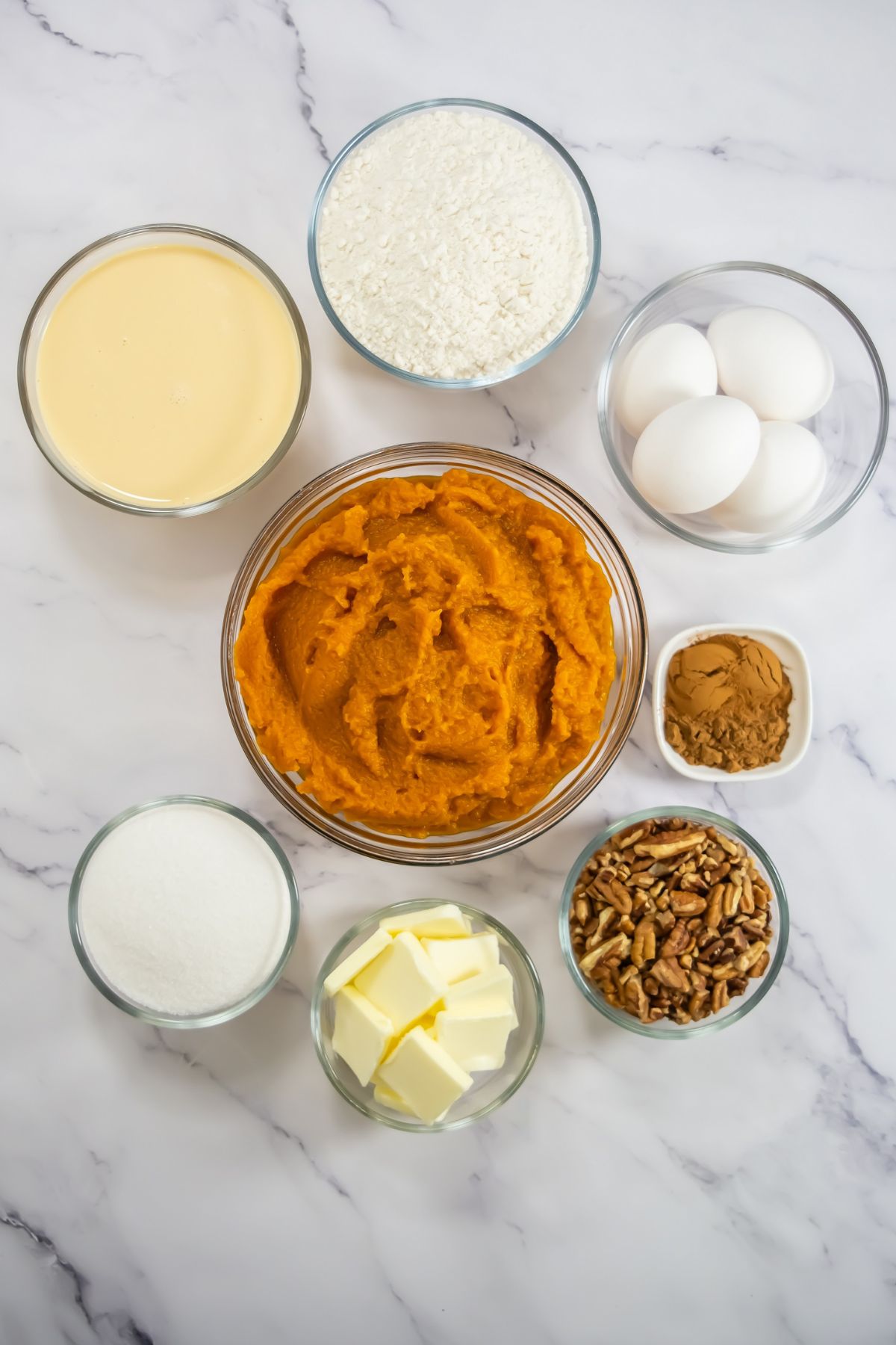 Pumpkin dump cake ingredients on a marble counter.