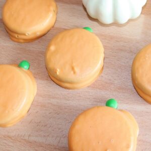 Pumpkin oreos on wooden table.