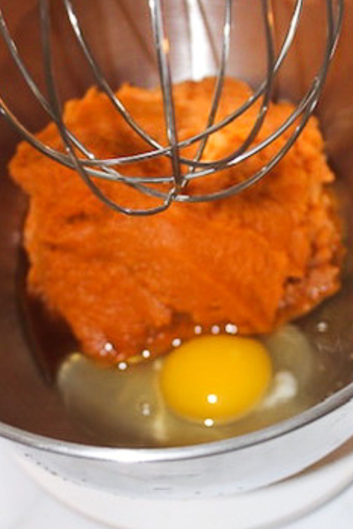 Adding egg to mixing bowl.