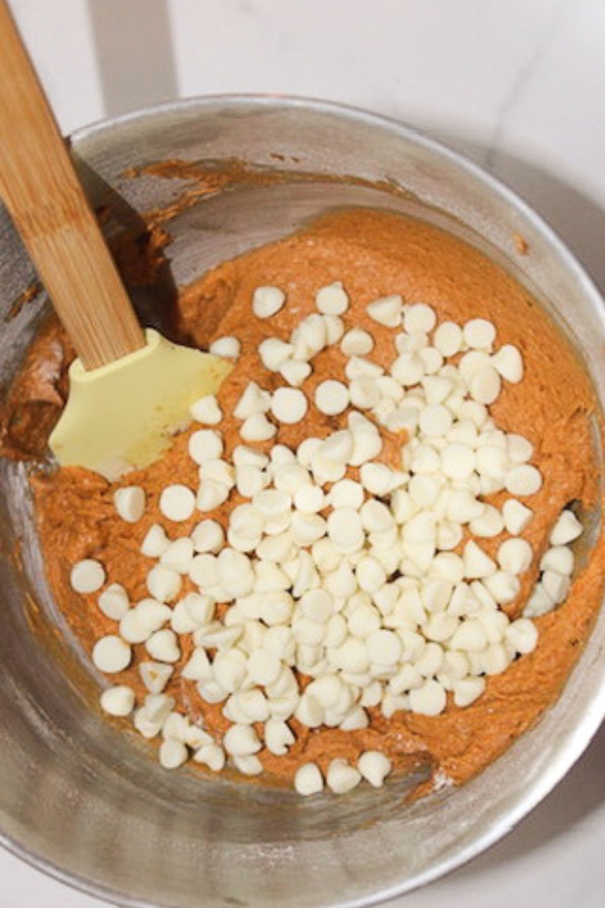 Stirring cream cheese chips into dough.