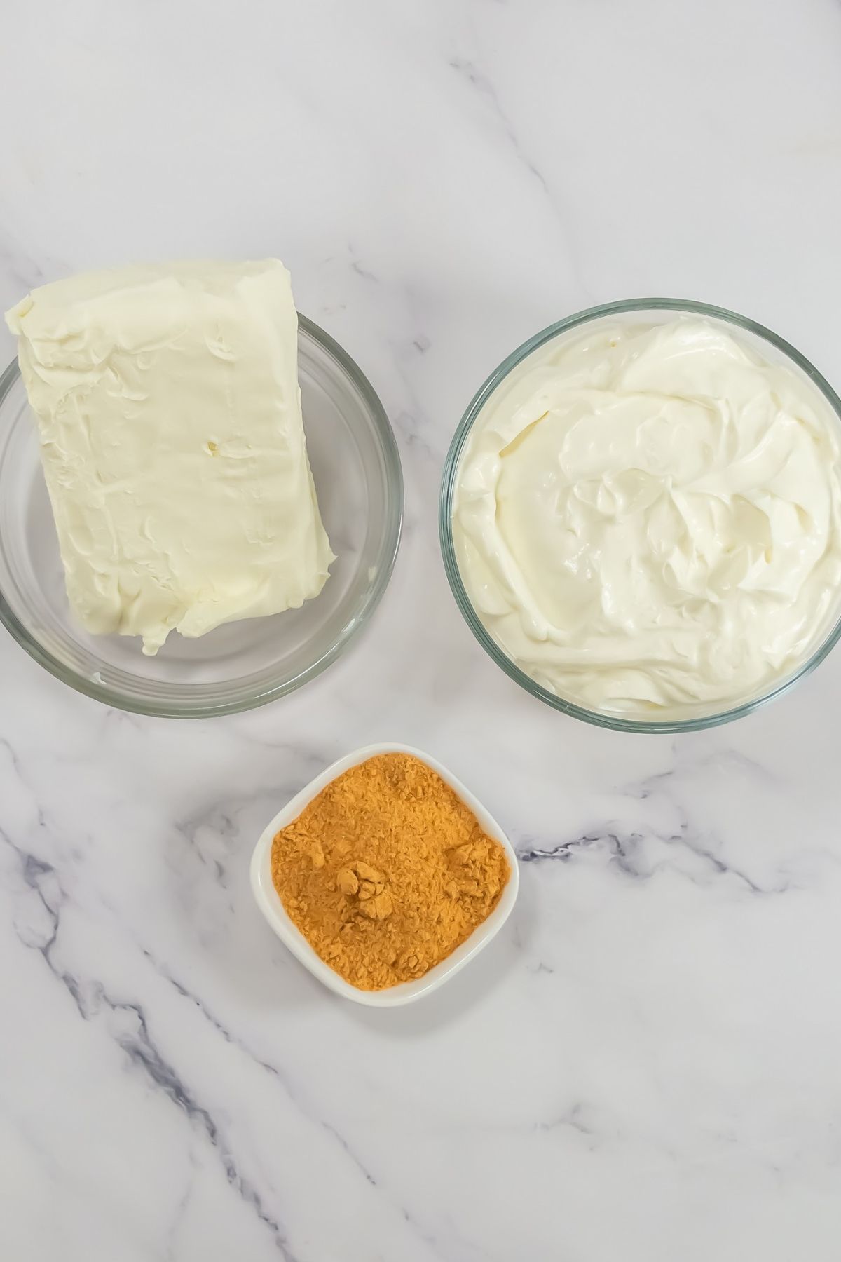 Taco dip ingredients on a marble counter.