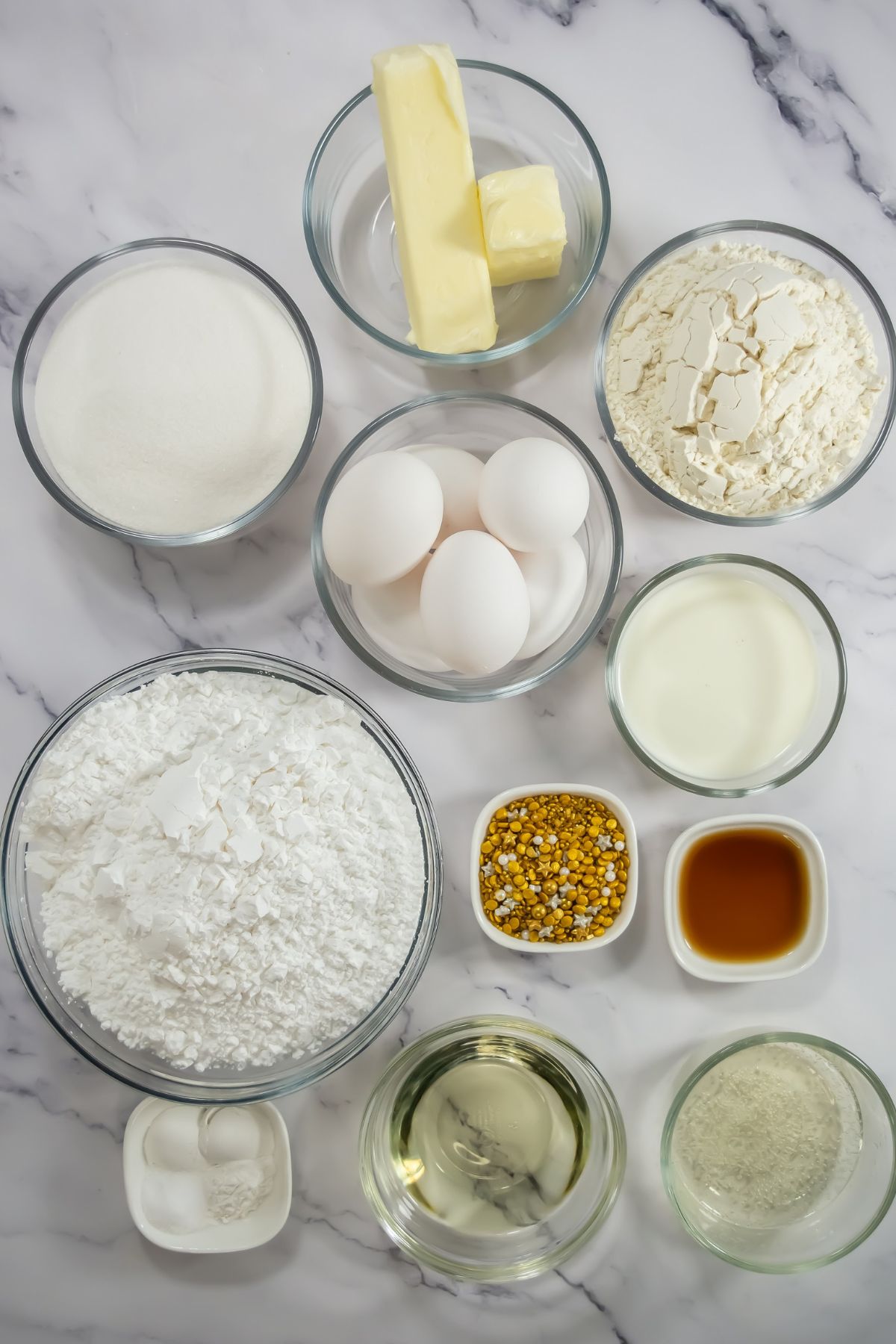 Champagne cupcake ingredients on marble table.