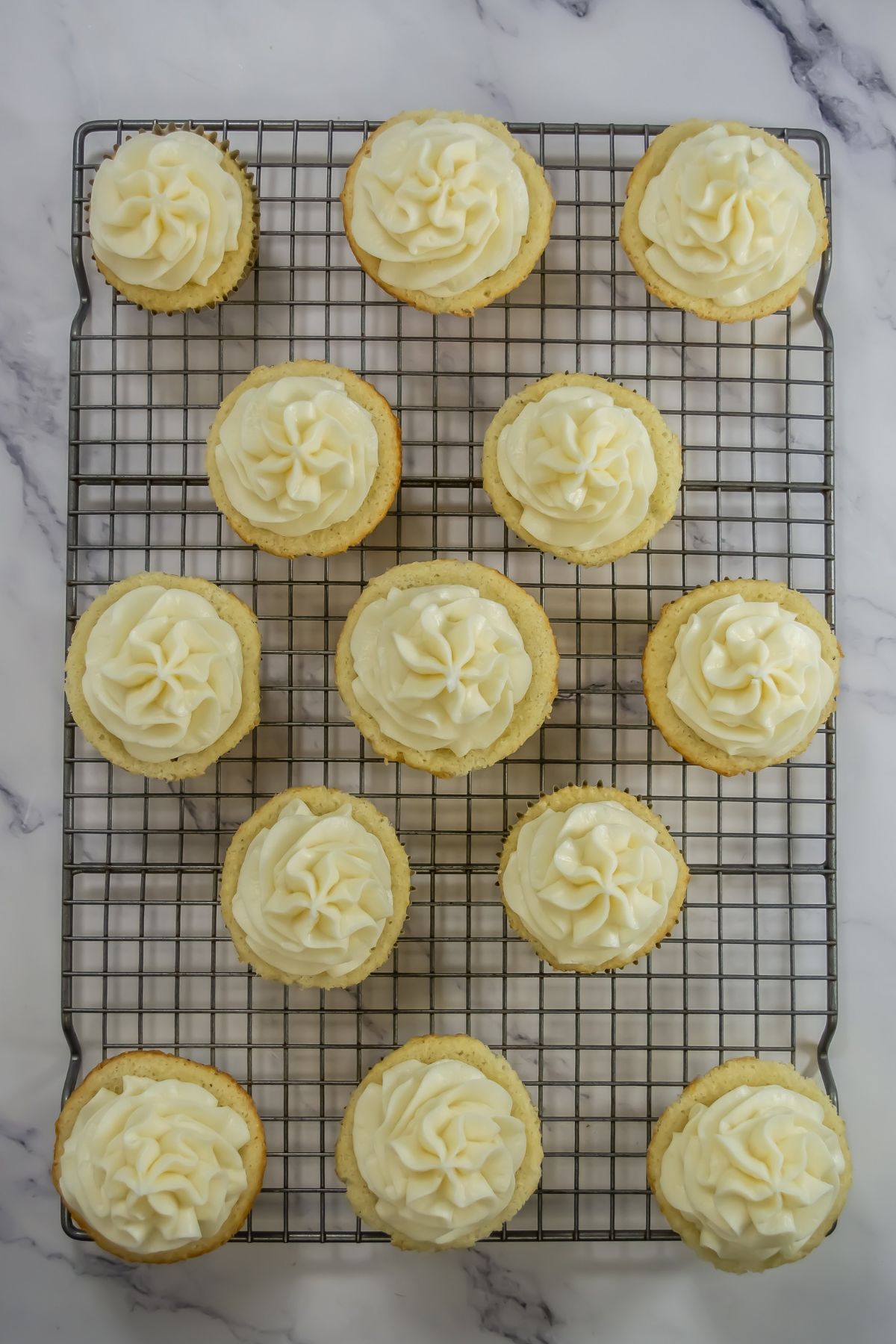 Champagne cupcakes on cooling rack.
