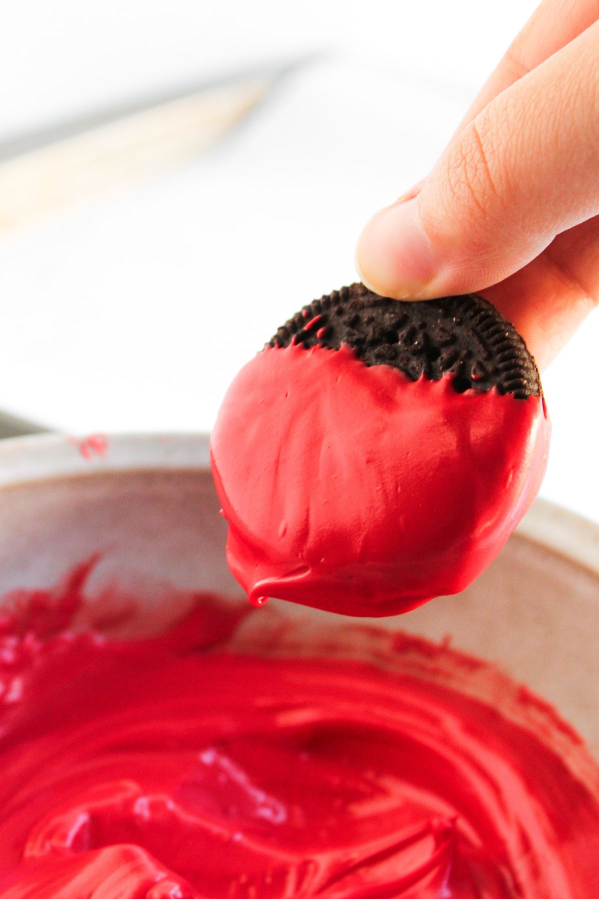 Dipping oreo in red candy melt.