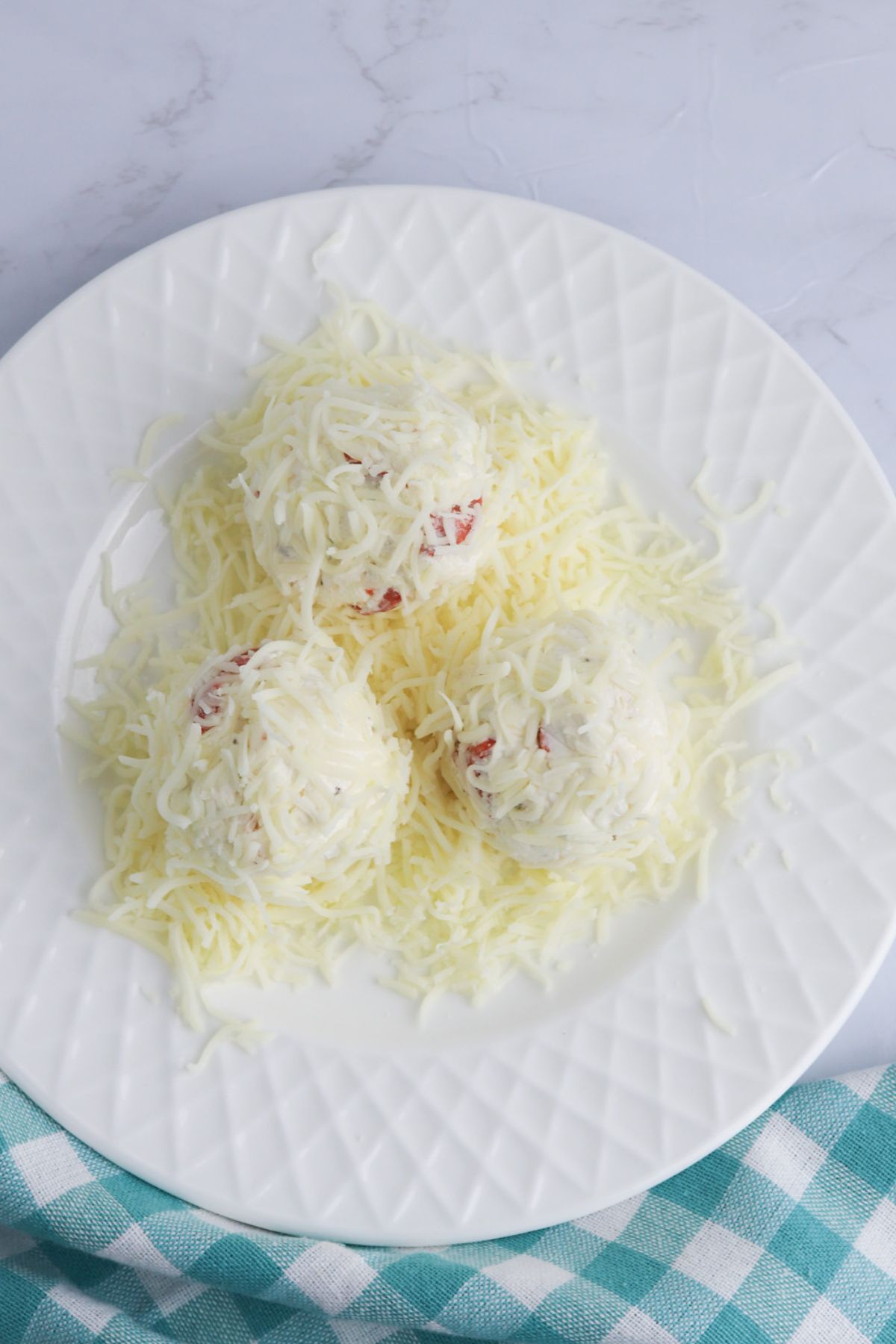 Balls coated in parmesan cheese.