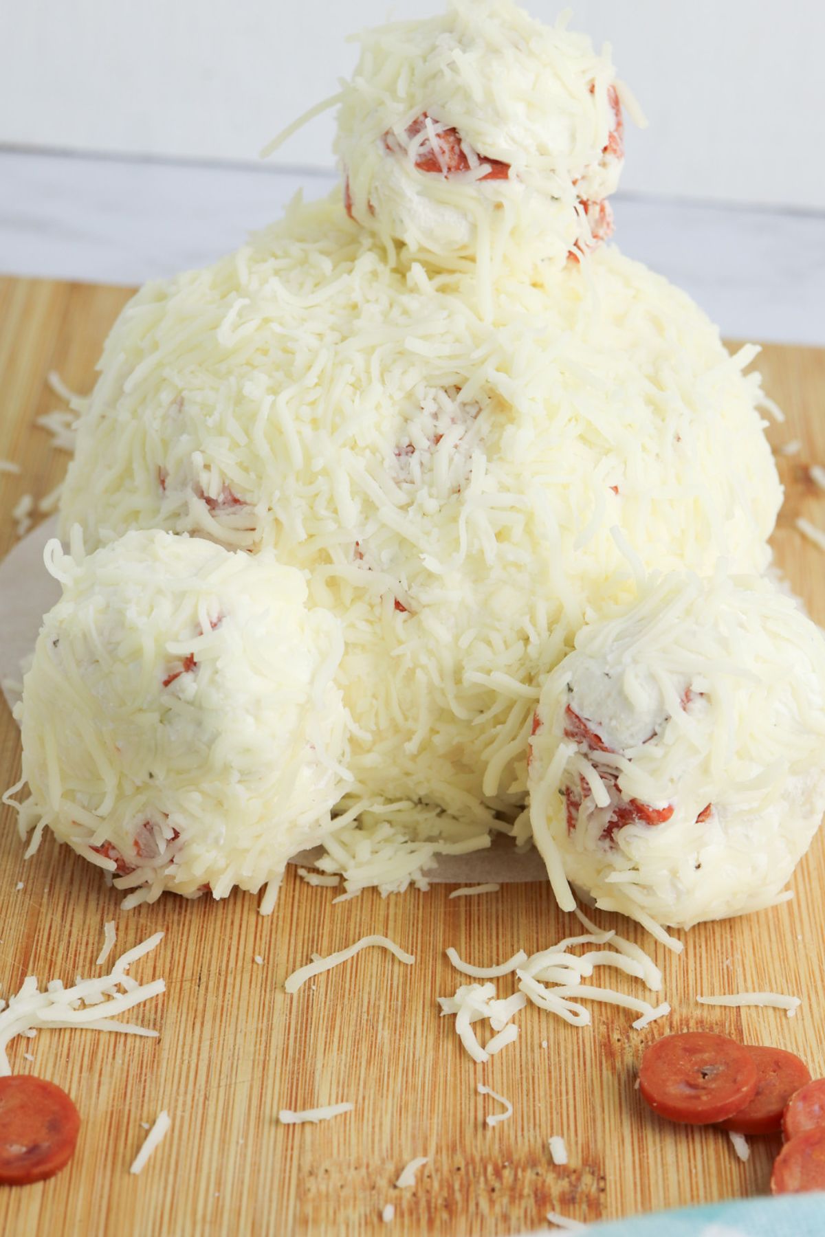 Bunny butt cheeseball on wooden board.