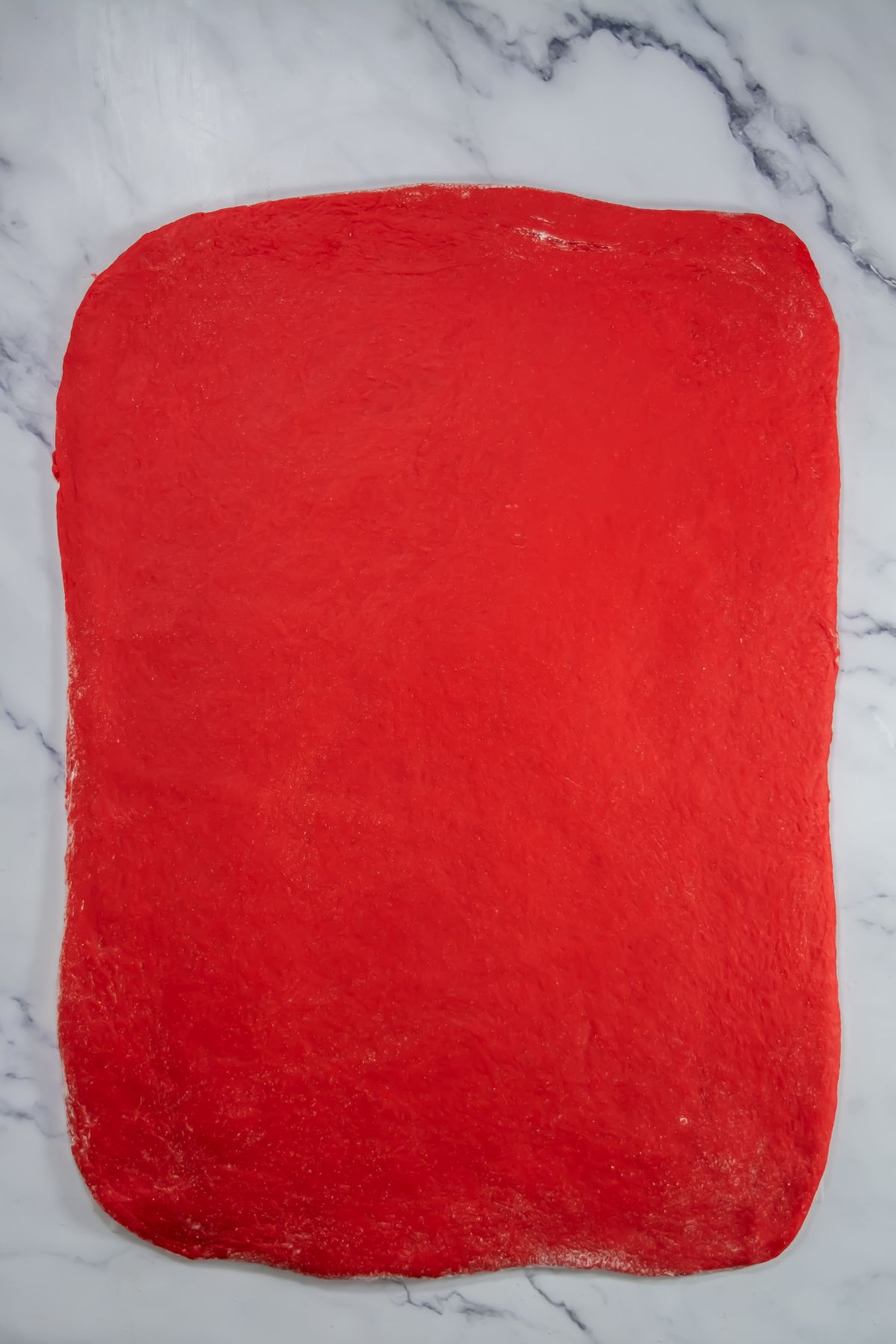 Red velvet dough on a marble table.