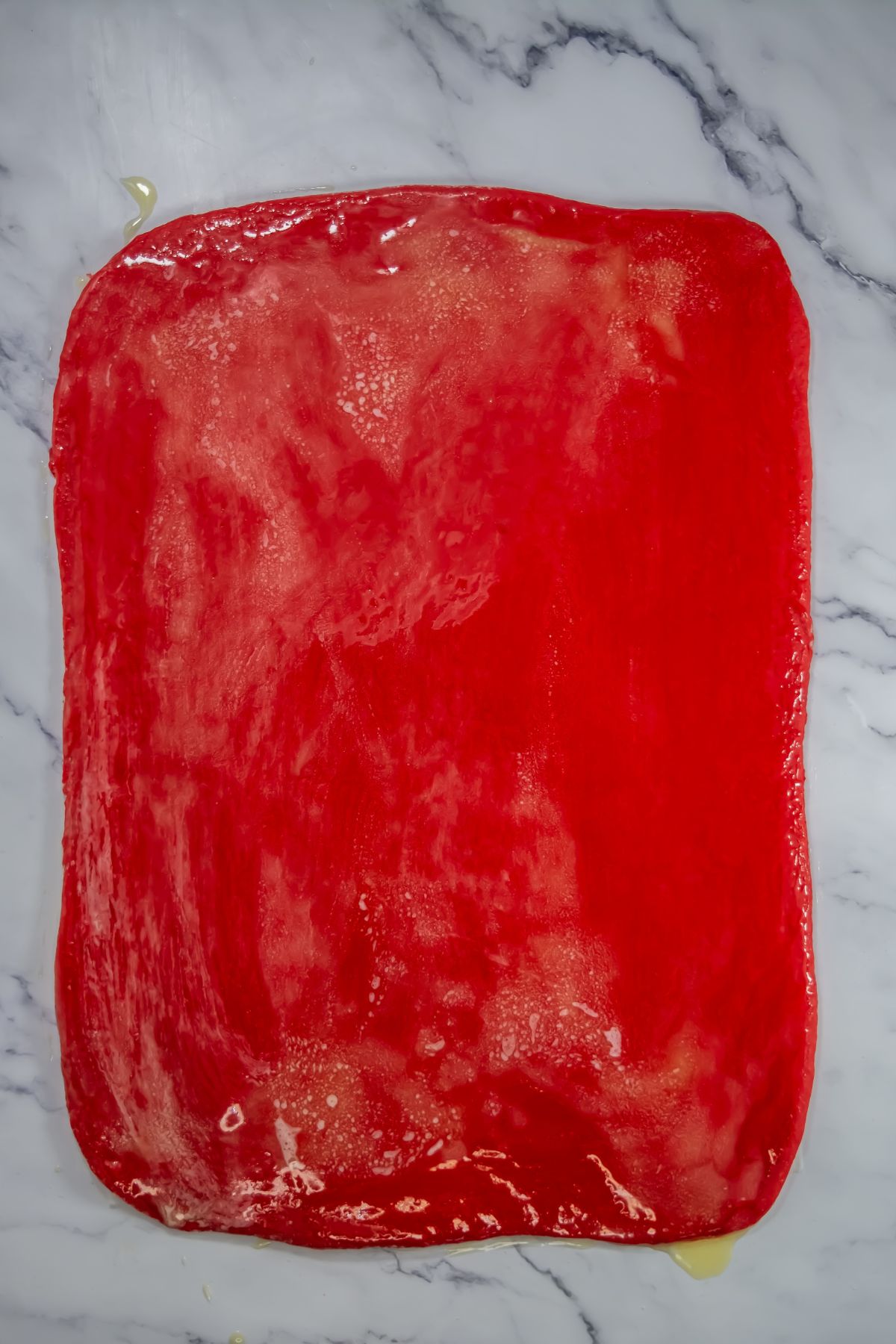 Red velvet dough on a marble table.