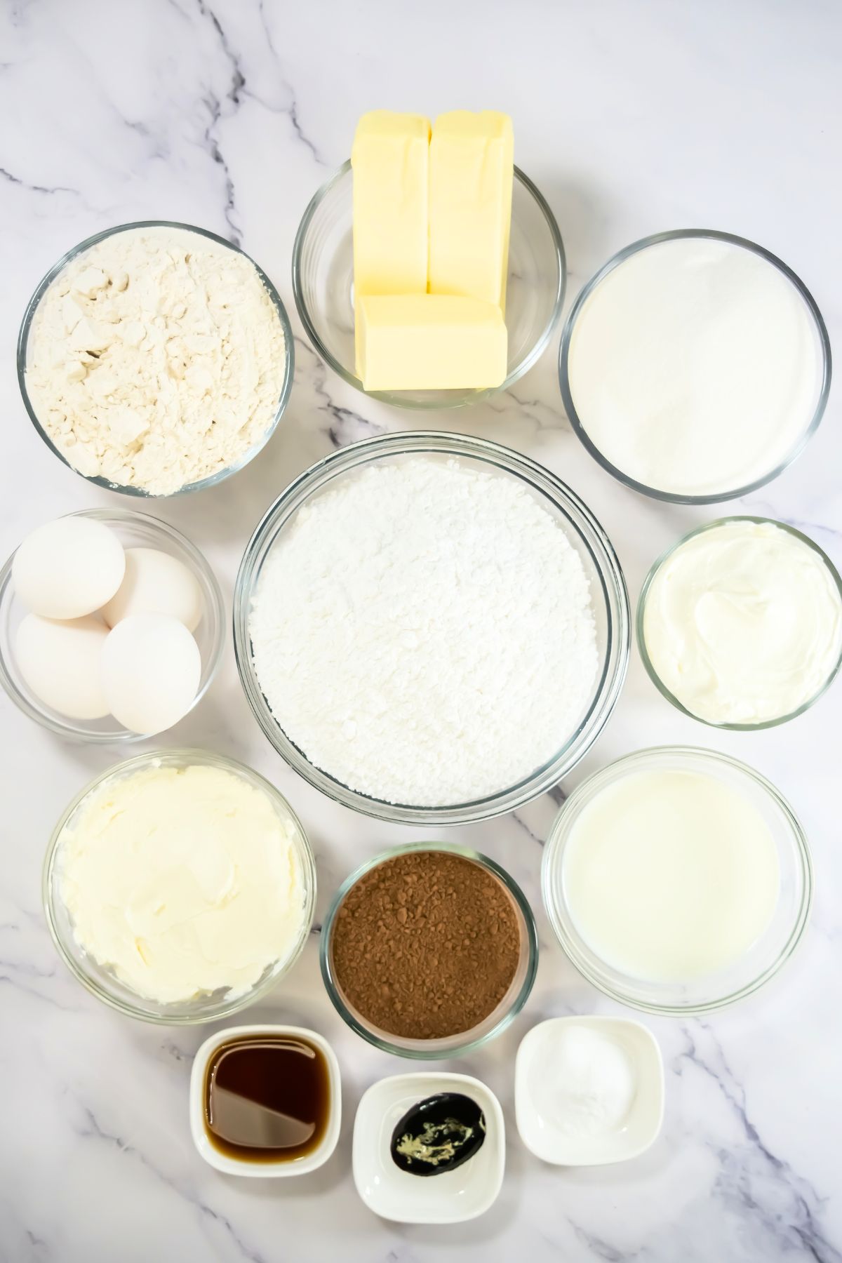 Red velvet cupcake ingredients on a marble counter.