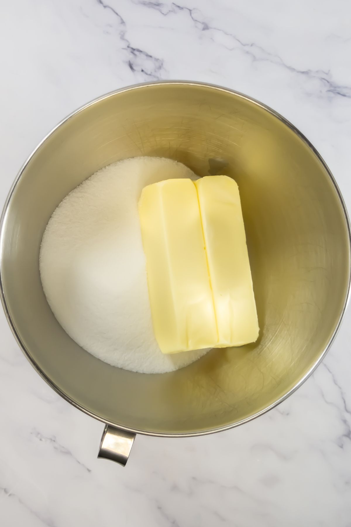 Sugar and butter in a mixing bowl.
