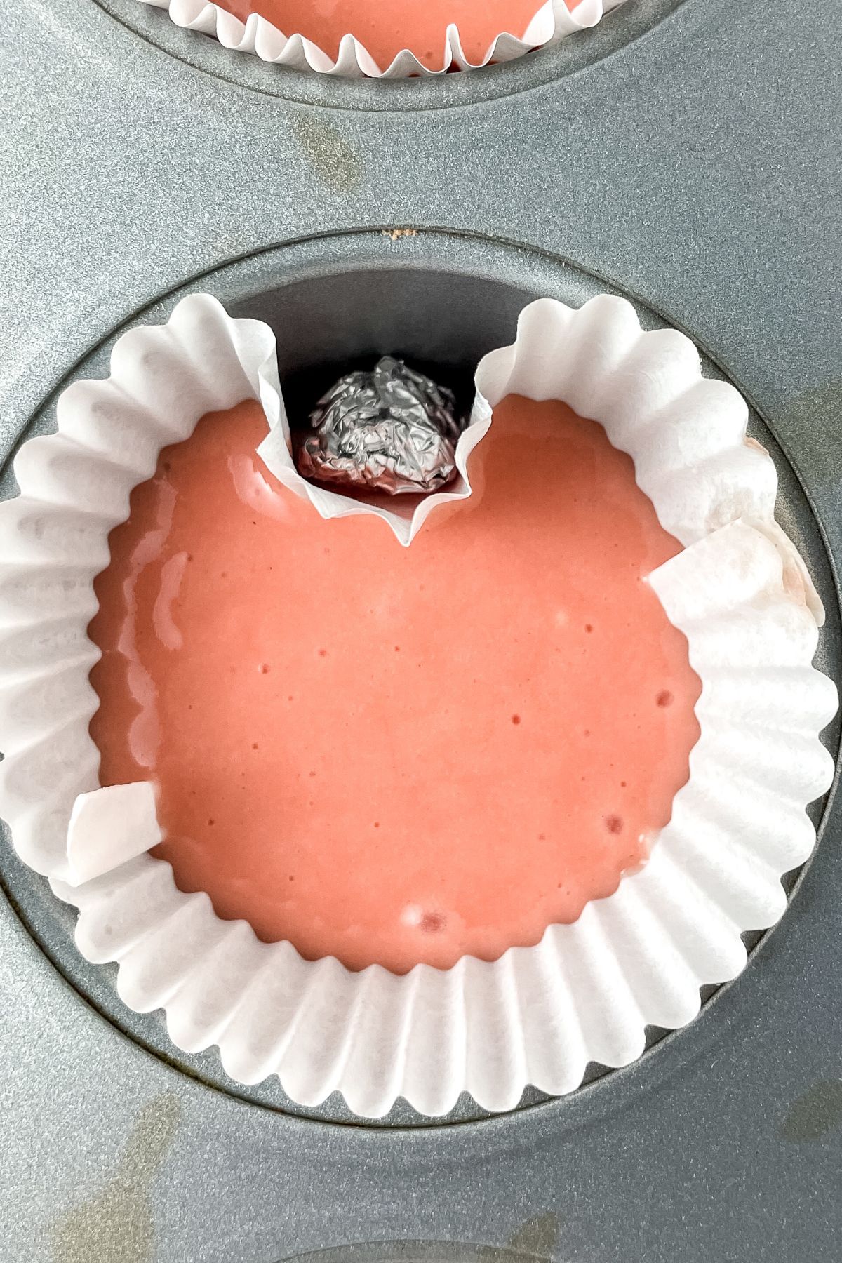 Strawberry cupcake batter in cupcake liner.