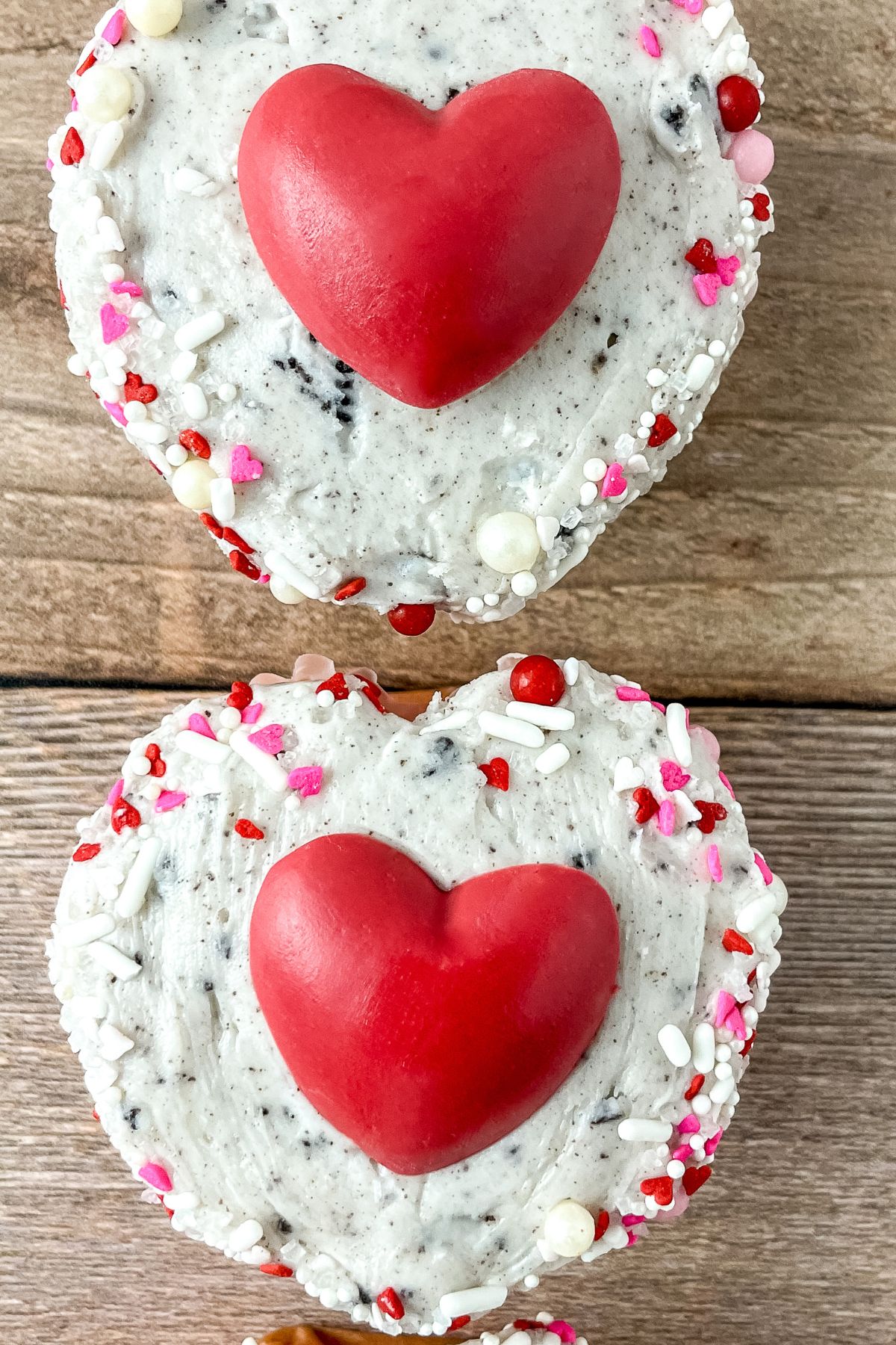 Strawberry and cream cupcakes on a wood surface.