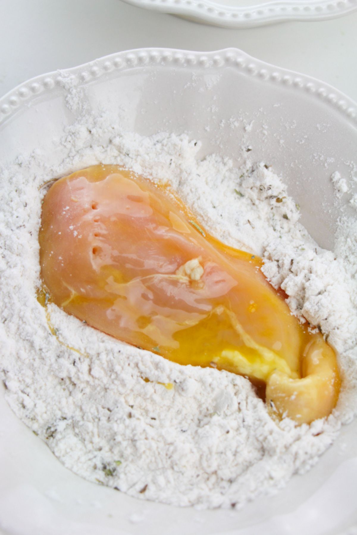 Chicken coated in egg in flour.