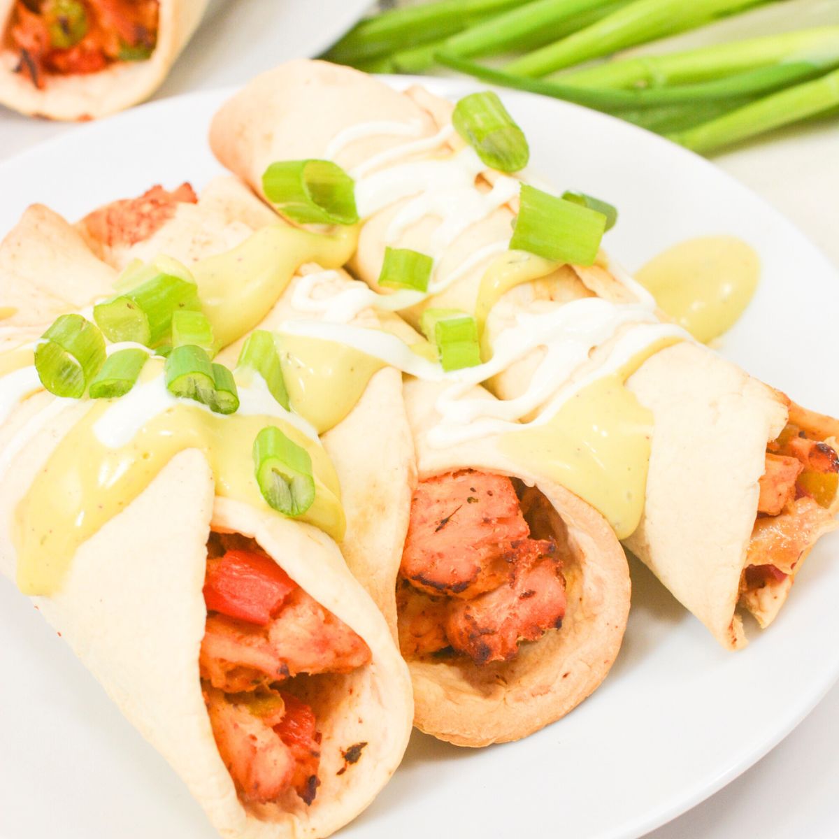 Air fryer green chile chicken taquitos on a plate.