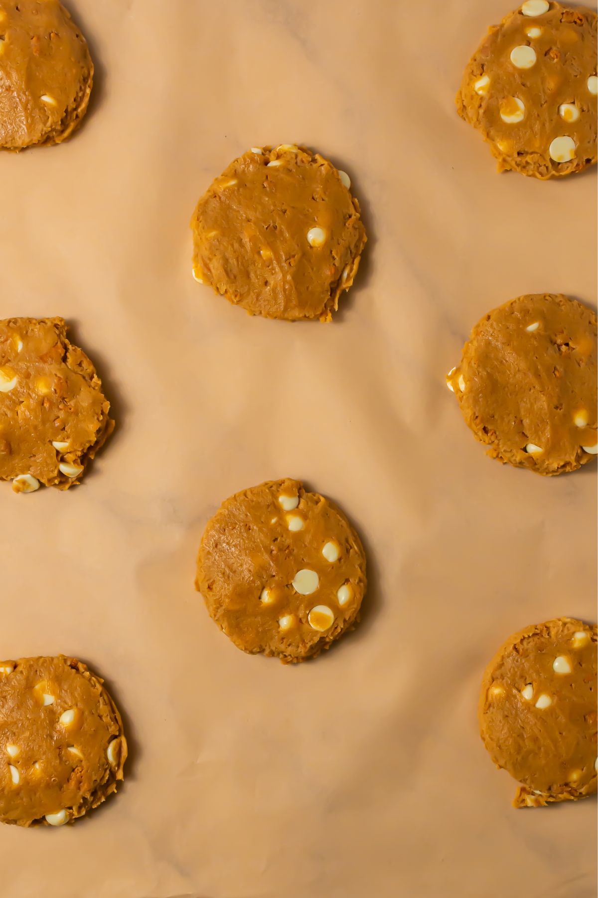 Biscoff white chocolate chip cookie dough on parchment paper.