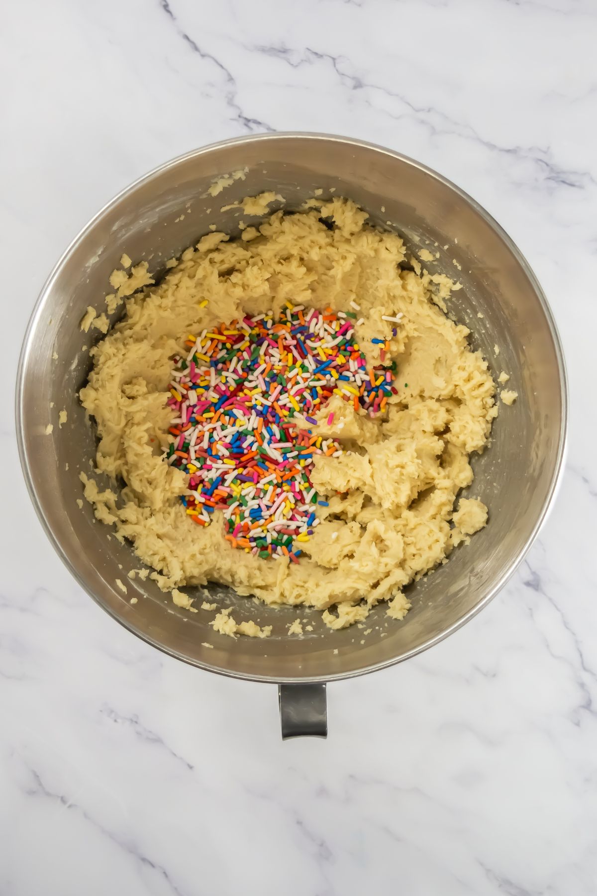 Adding sprinkles into cookie dough.