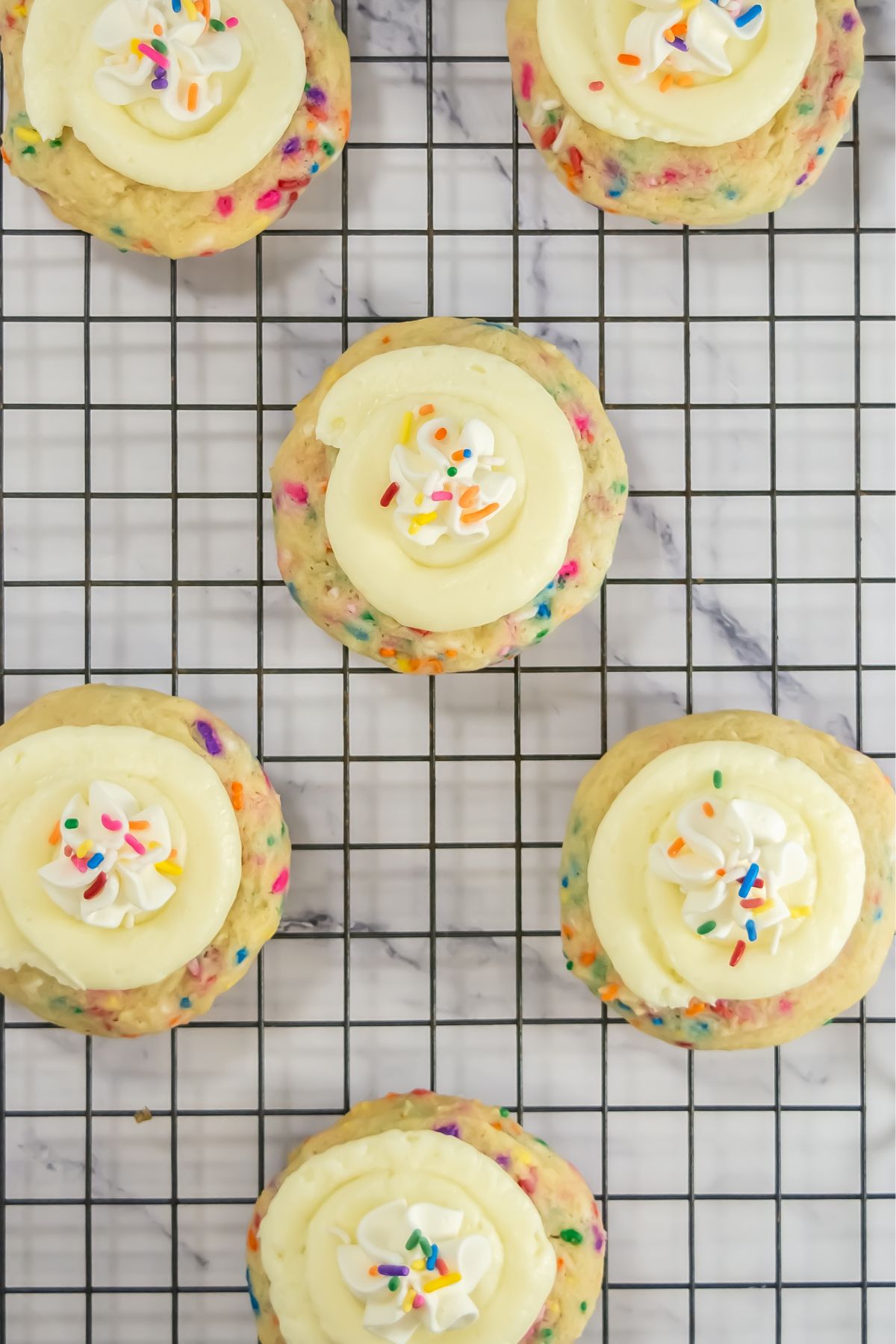 Crumbl funfetti cookies on a cooling rack.