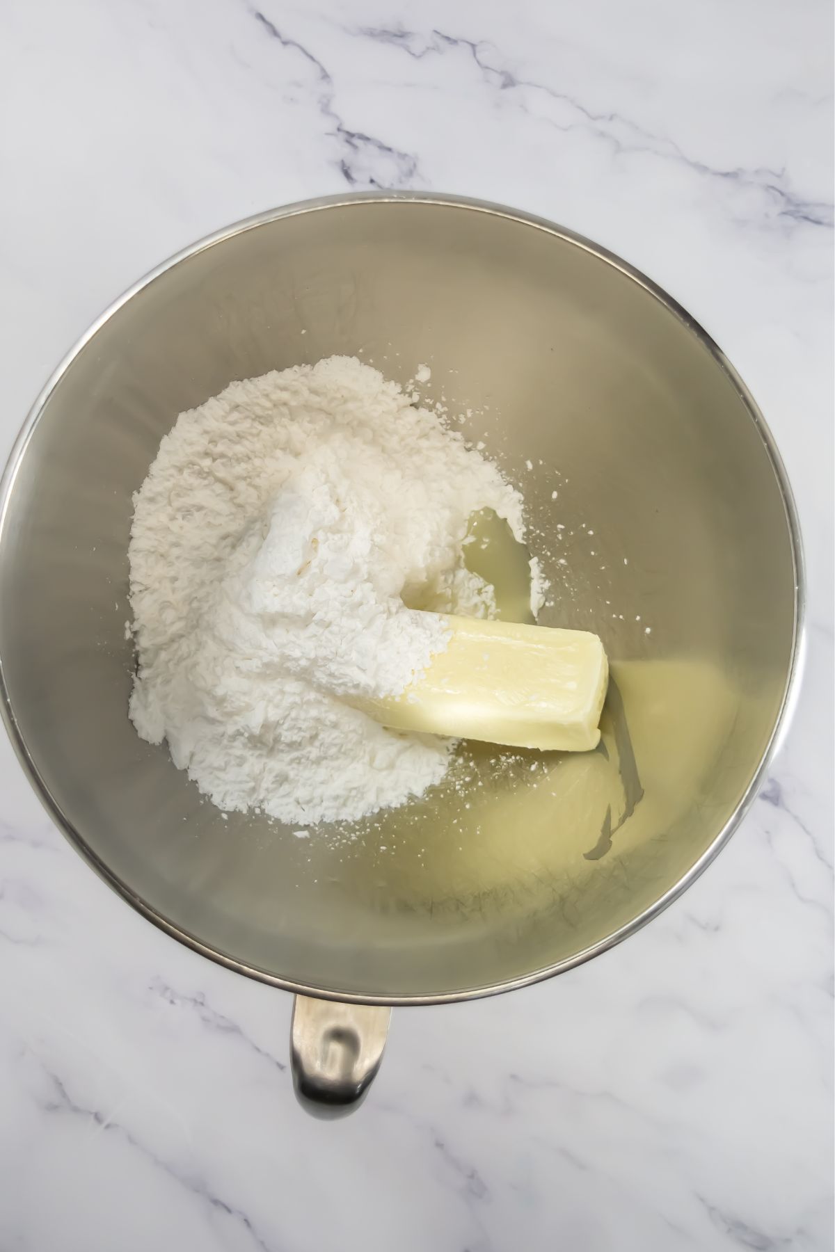 Powdered sugar and butter in a mixing bowl.