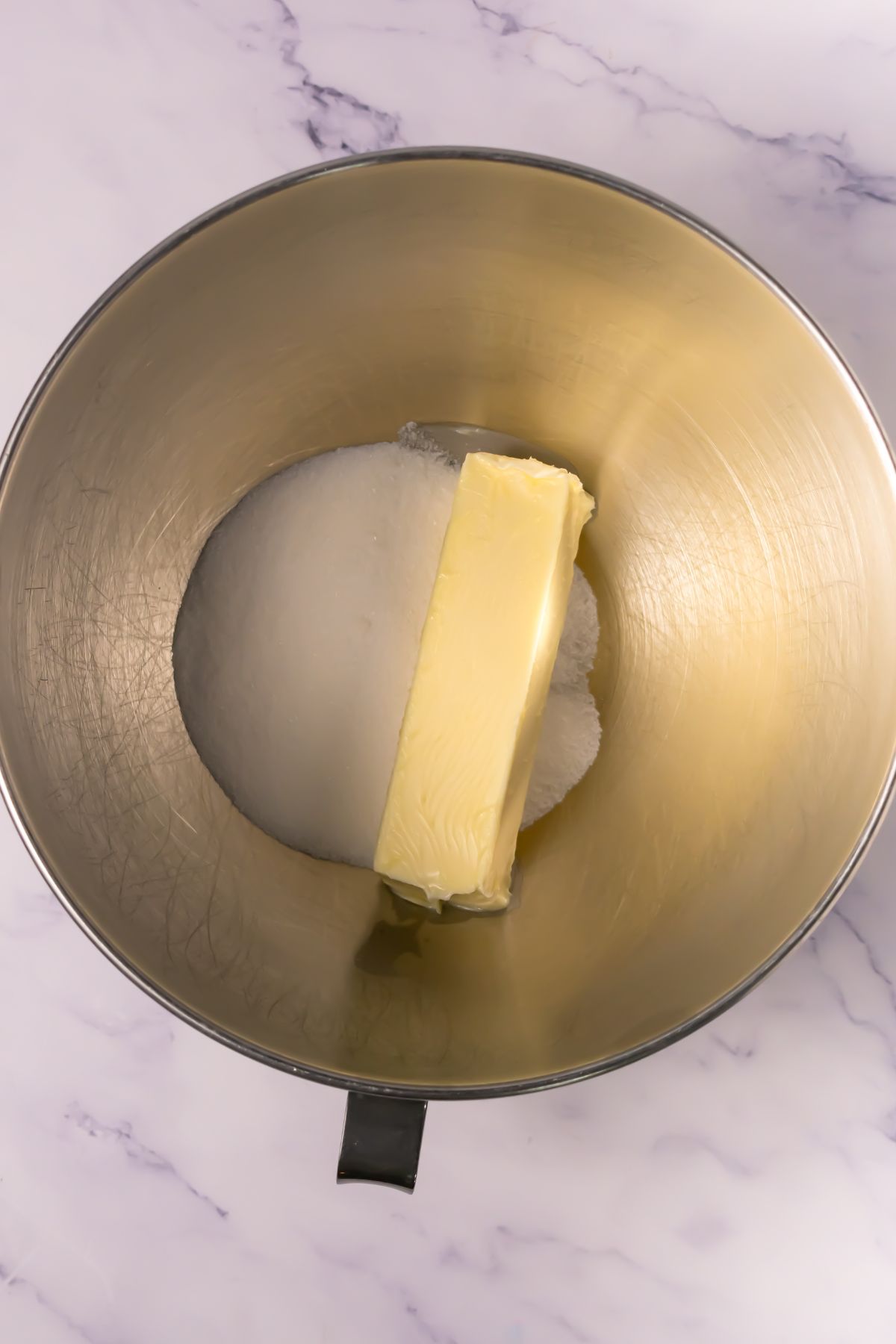 Sugar and butter in a mixing bowl.