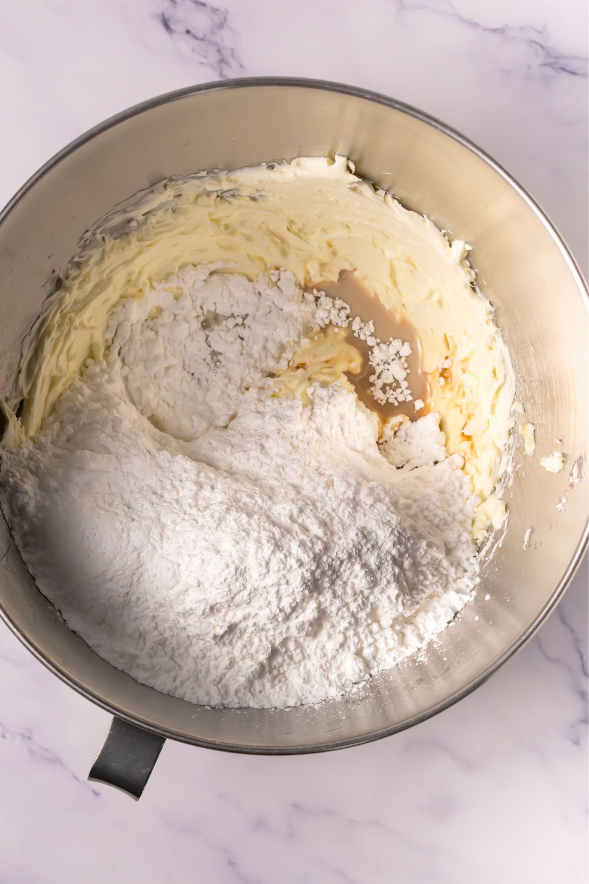 Flour added to cookie dough in bowl.