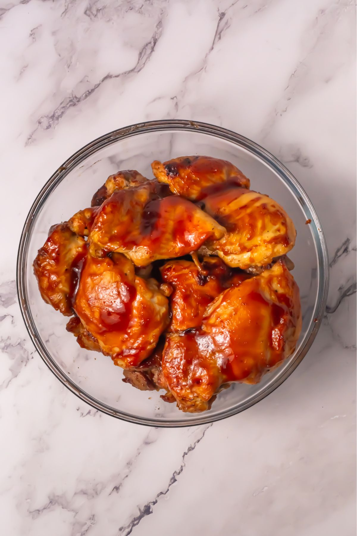 Chicken thighs with BBQ sauce in a bowl.