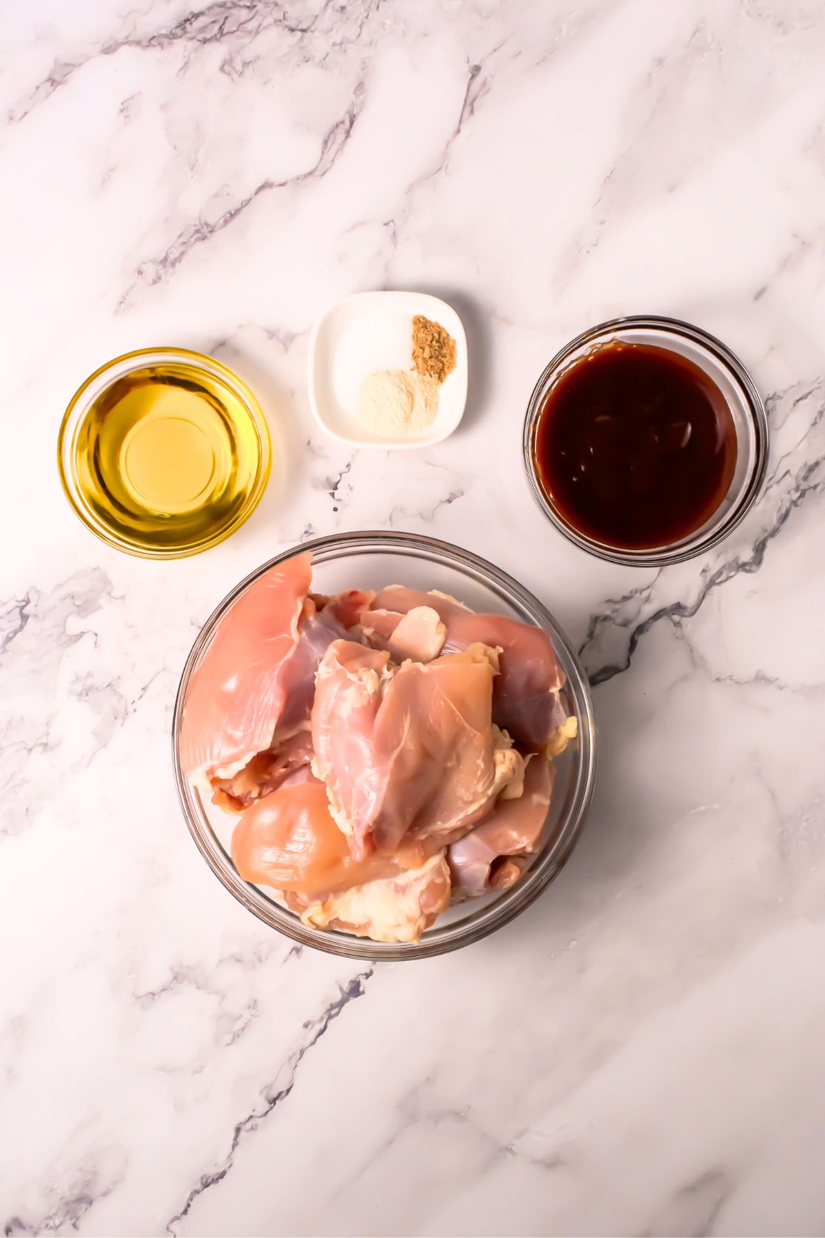 Air fryer BBQ chicken thigh ingredients on a marble counter.