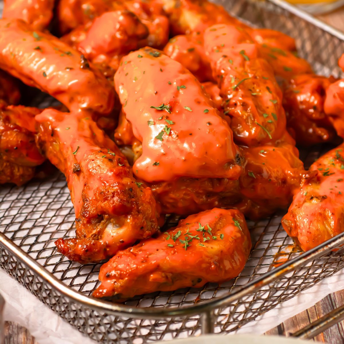 Air fryer chicken wings in a basket.