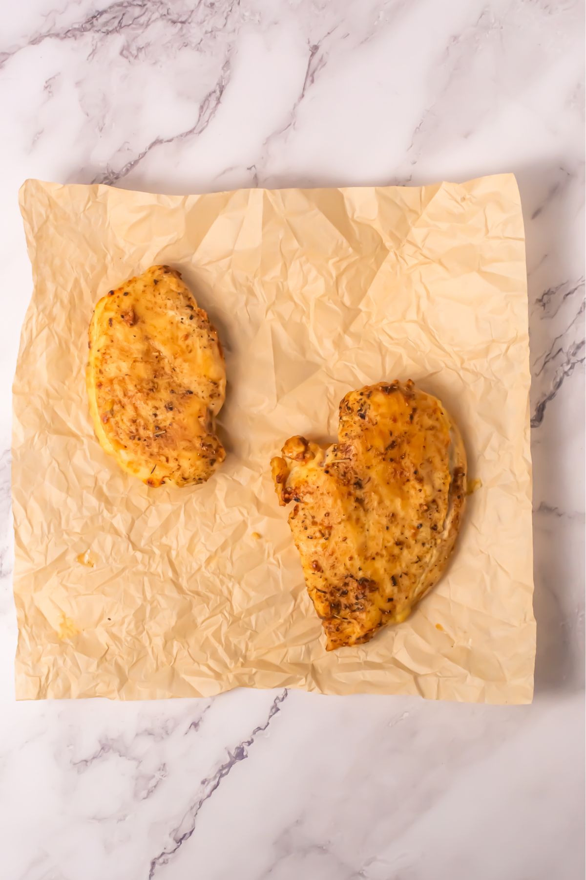 Sliced, cooked chicken breast on parchment paper.