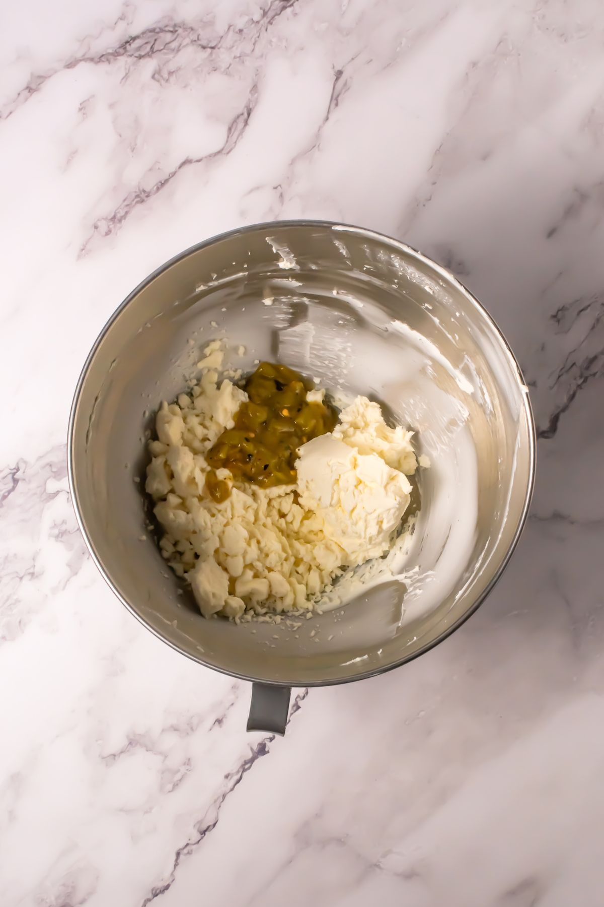 Spices and cream cheese in a mixing bowl.