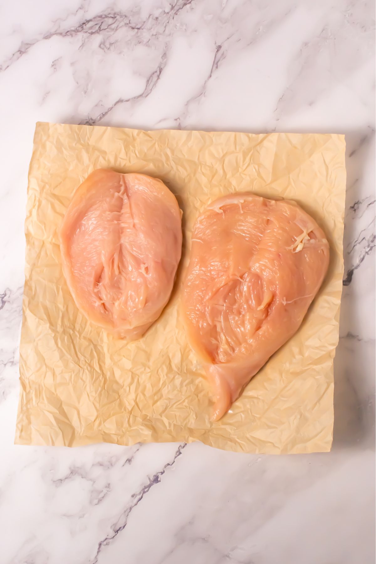 Sliced chicken breast on parchment paper.