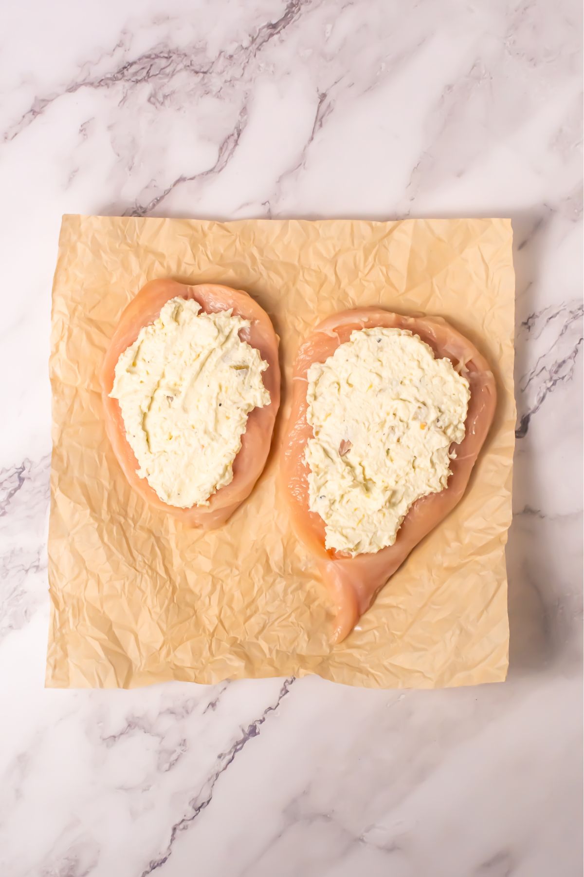 Sliced chicken breast with filling on parchment paper.