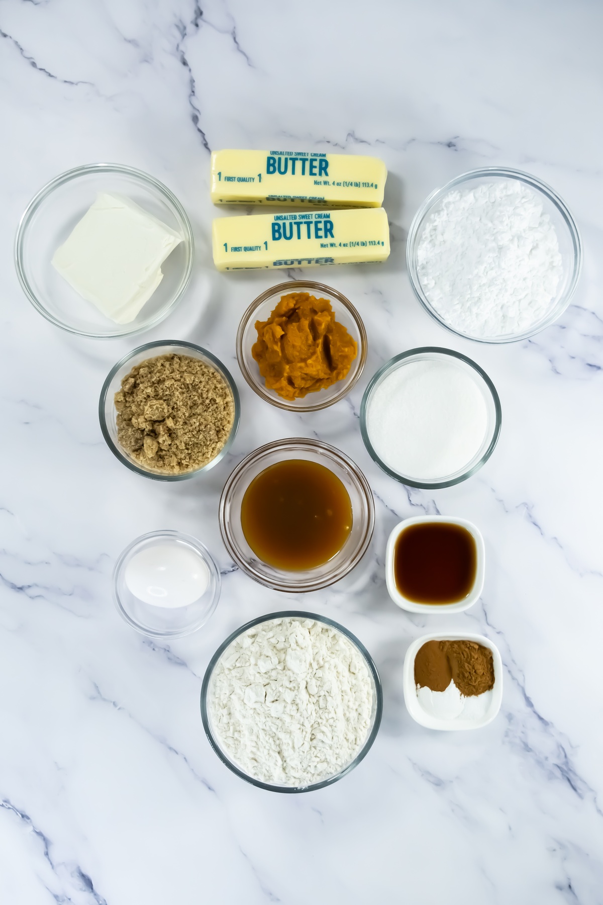 Ingredients for crumbl caramel pumpkin cookies on a marble table.