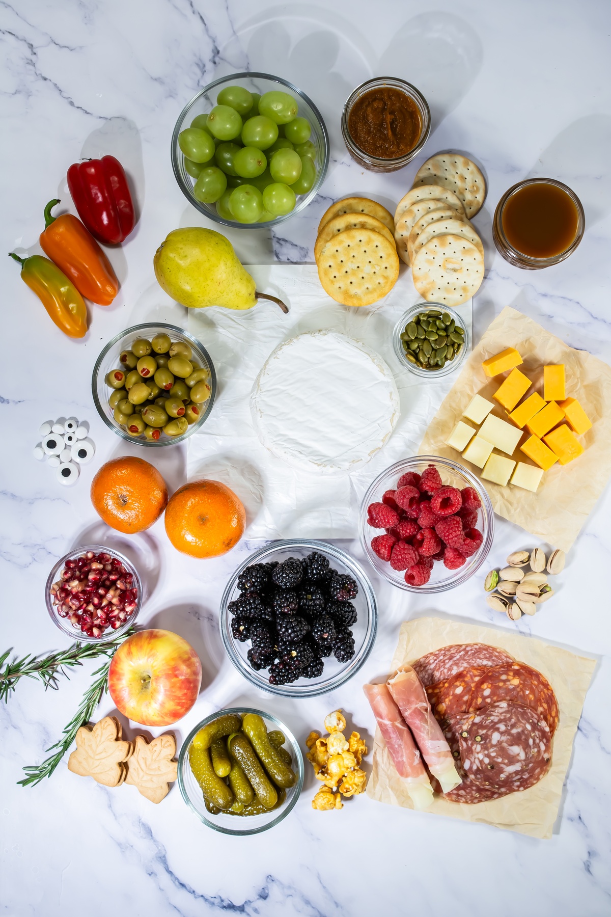 Ingredients for fall charcuterie board on a marble table.