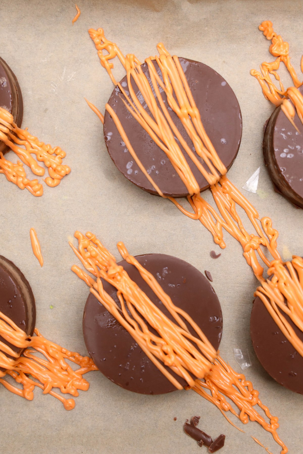 Chocolate covered oreos with orange drizzle on top.