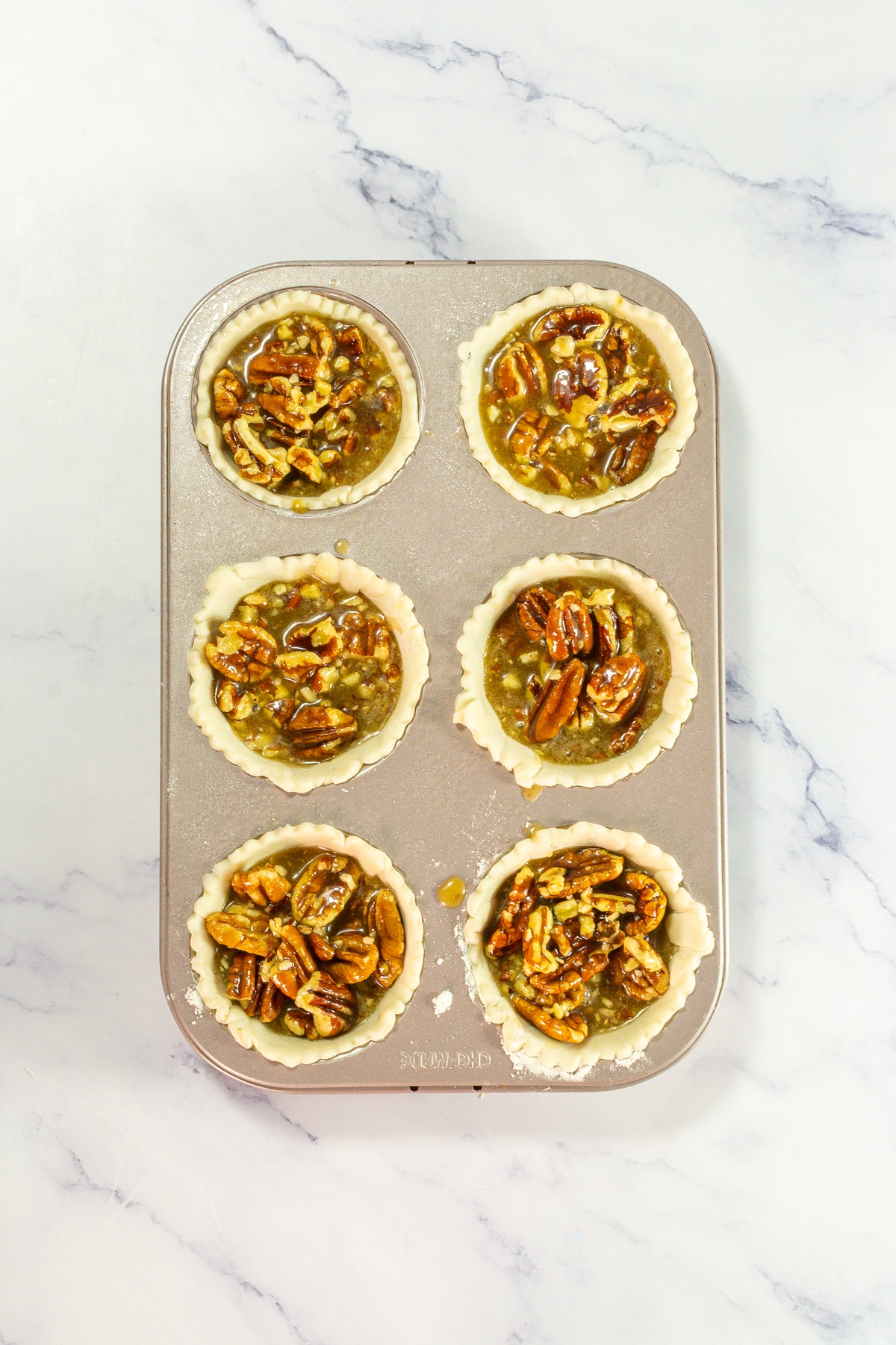 Pecan mixture added to pie crusts.