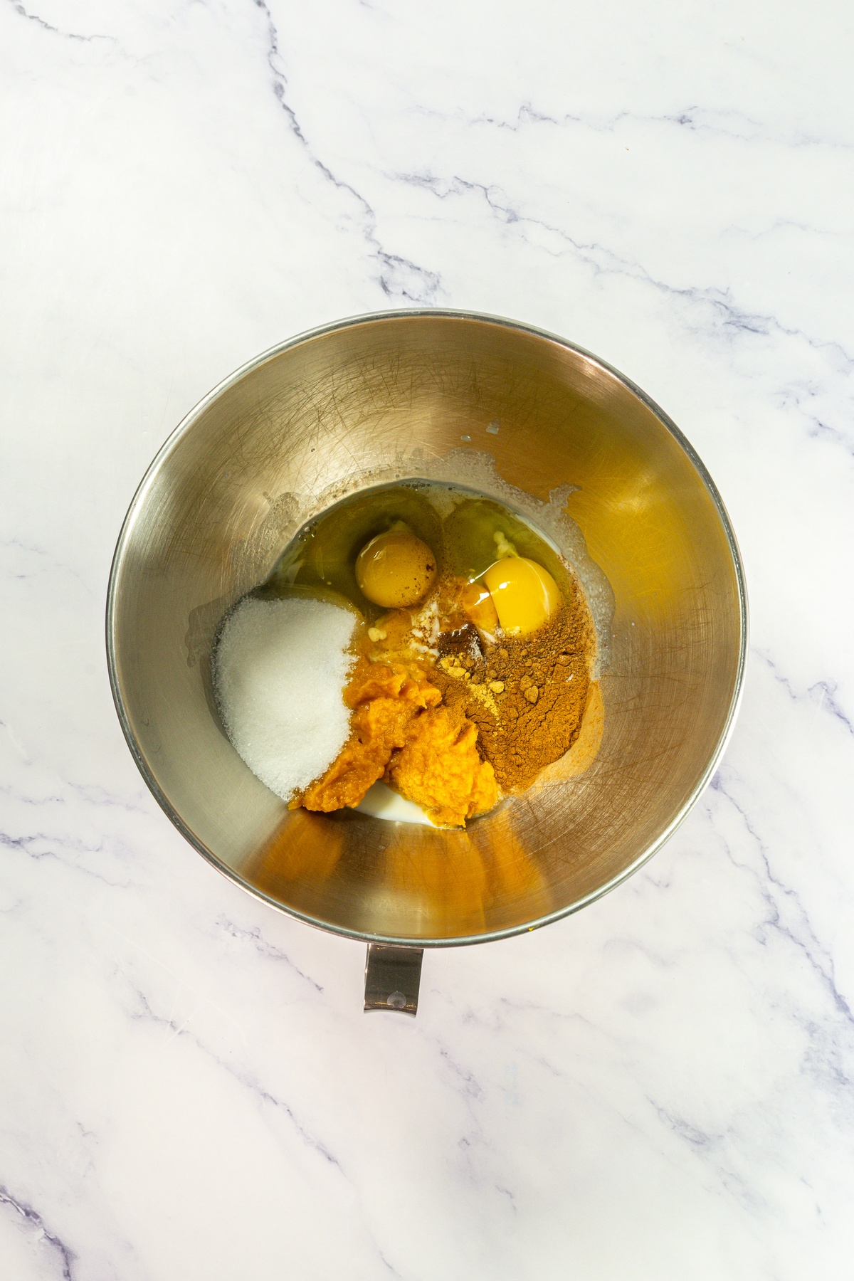Eggs, pumpkin and spices in a bowl.