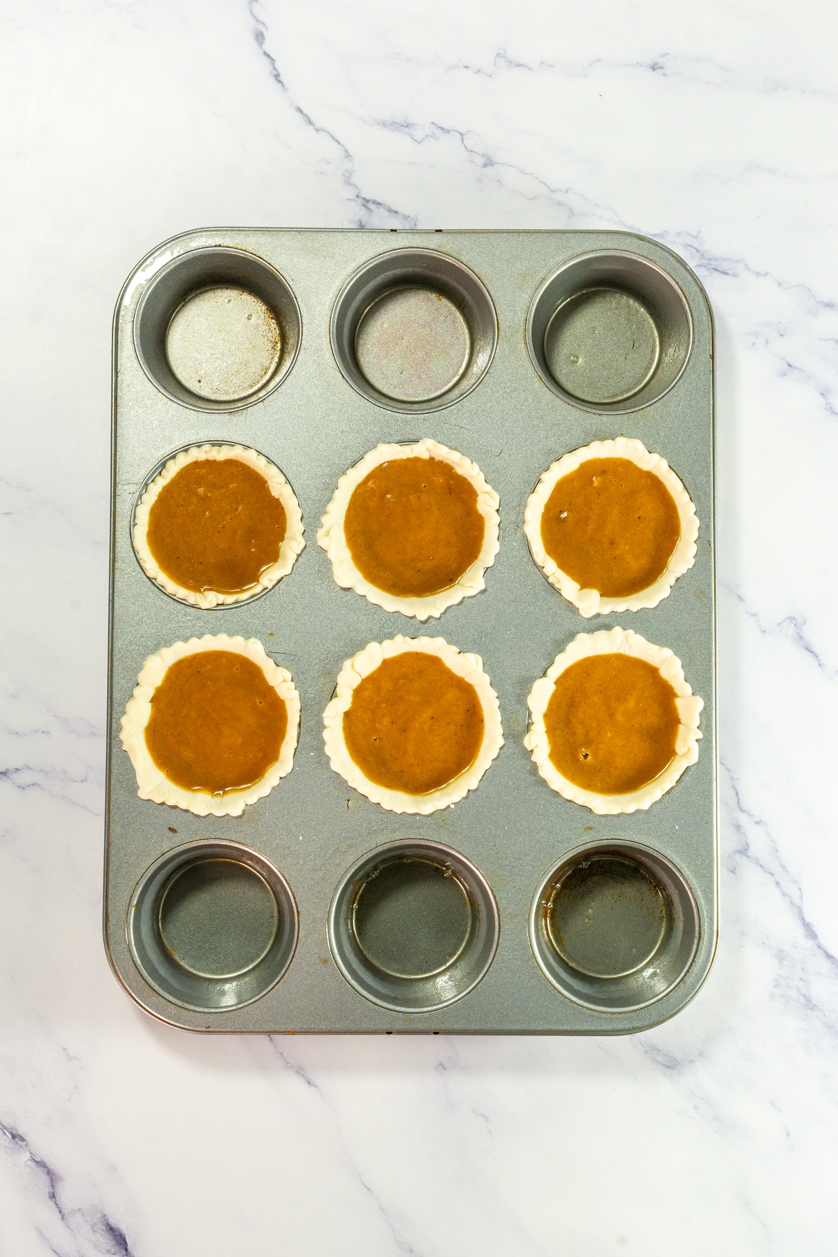 Pie crusts filled with pumpkin pie fillihg.