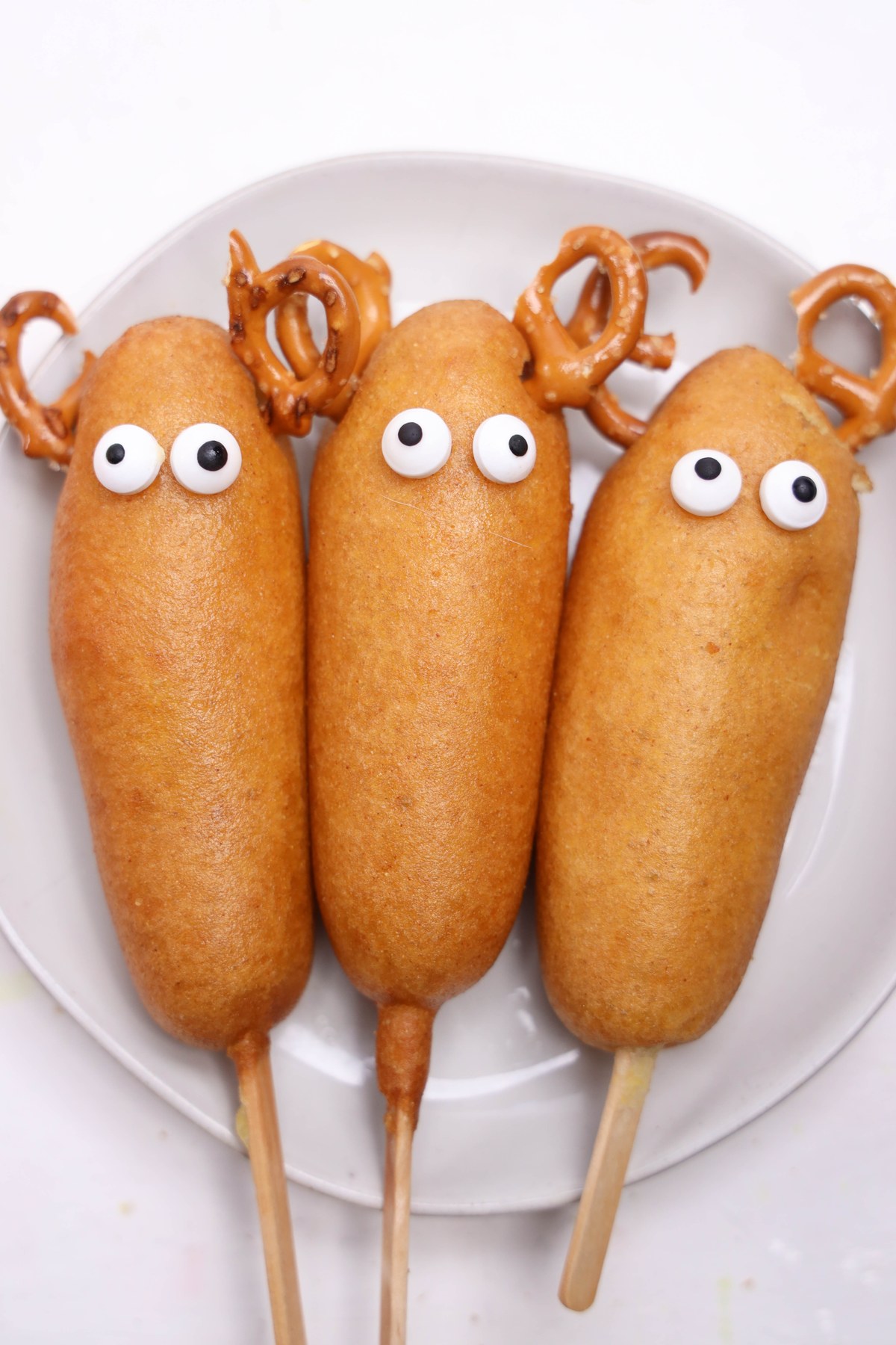 Corn dogs with candy eyes added on them.