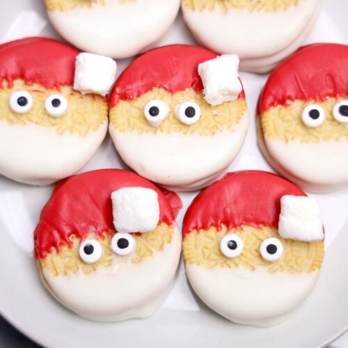 Decorated Oreos designed to look like Santa faces.