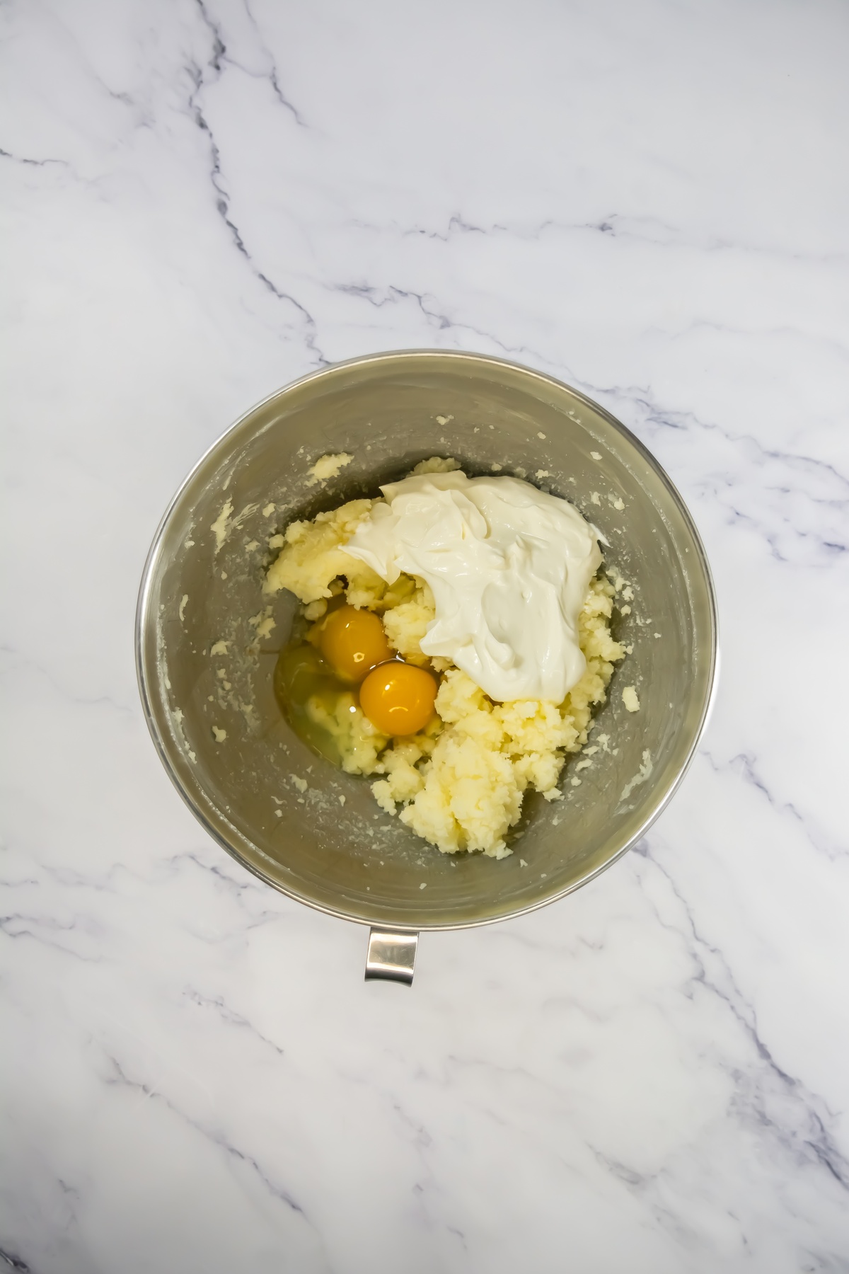 Creamed butter and sugar with eggs in a bowl.
