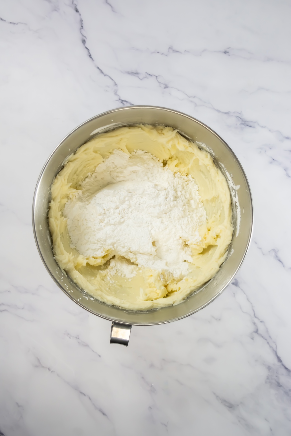 More powdered sugar in a bowl with frosting.
