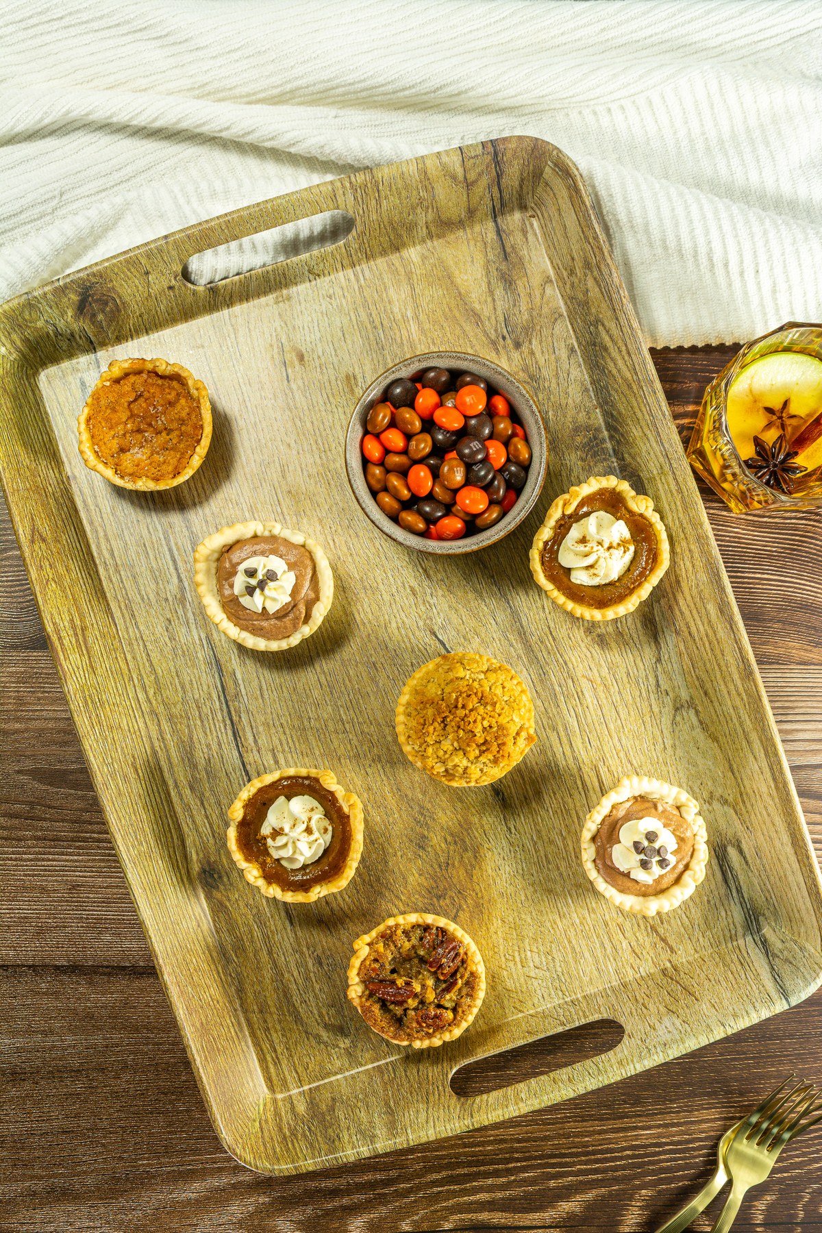 Mini pies and candies on a dessert board.